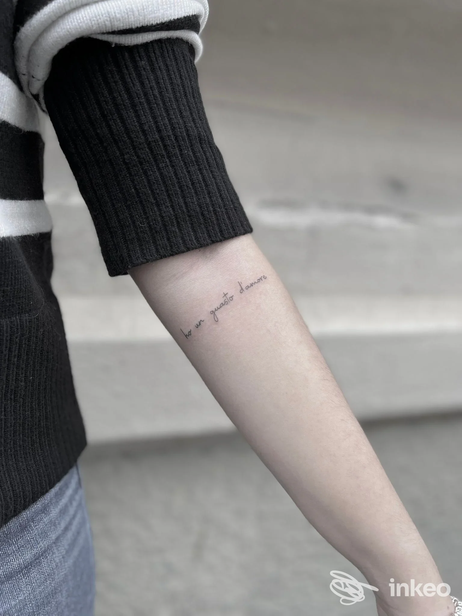 Primo piano di un avambraccio con tatuaggio testuale sottile in nero, foto realizzata per C4 Tattoo Studio a Genova.