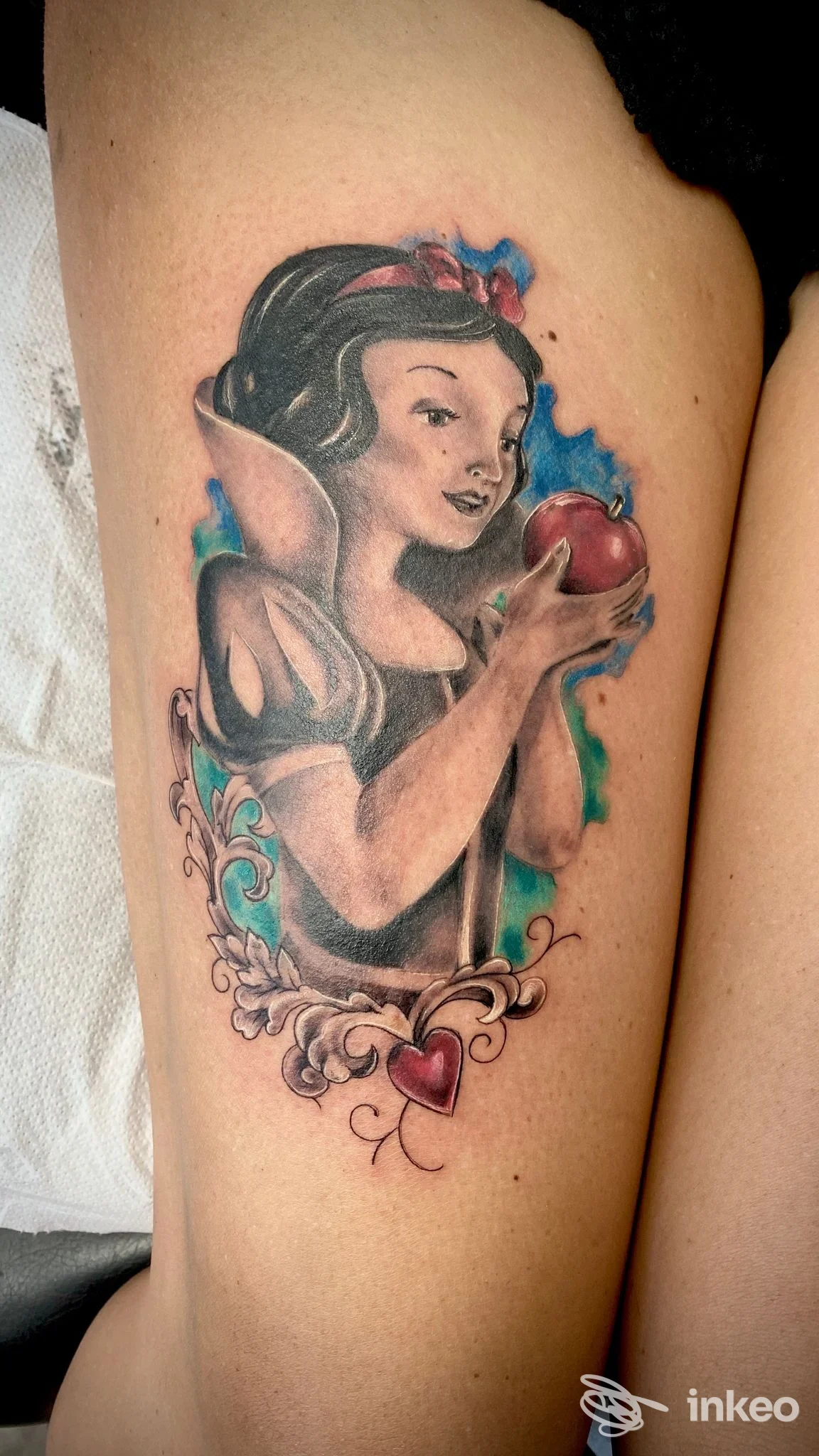 Tatuaggio figurativo di Biancaneve con mela rossa sul lato della coscia, realizzato da Blood Love Tattoo a Genova.