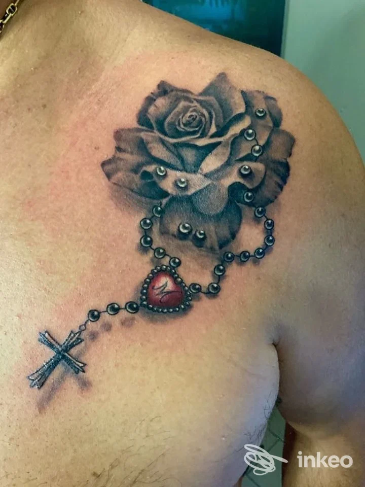 Tatuaggio a rosa con rosario e cuore rosso sulla spalla/parte alta del petto, Derek Smith Tattoo studio, Pietra Ligure.