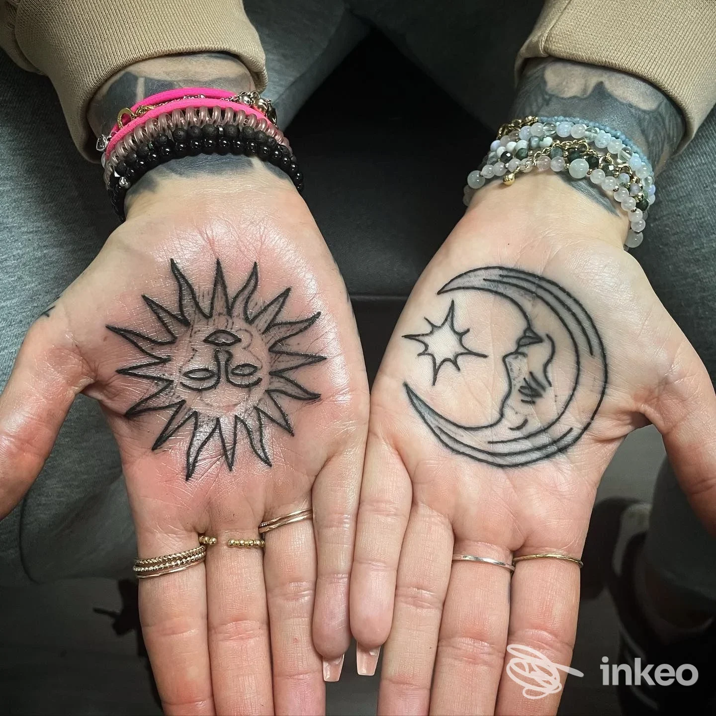 Due palmi tatuati: un sole stilizzato sul palmo sinistro e una luna con volto e stella sul palmo destro. Ettore Groccia Tattoo, Genova.