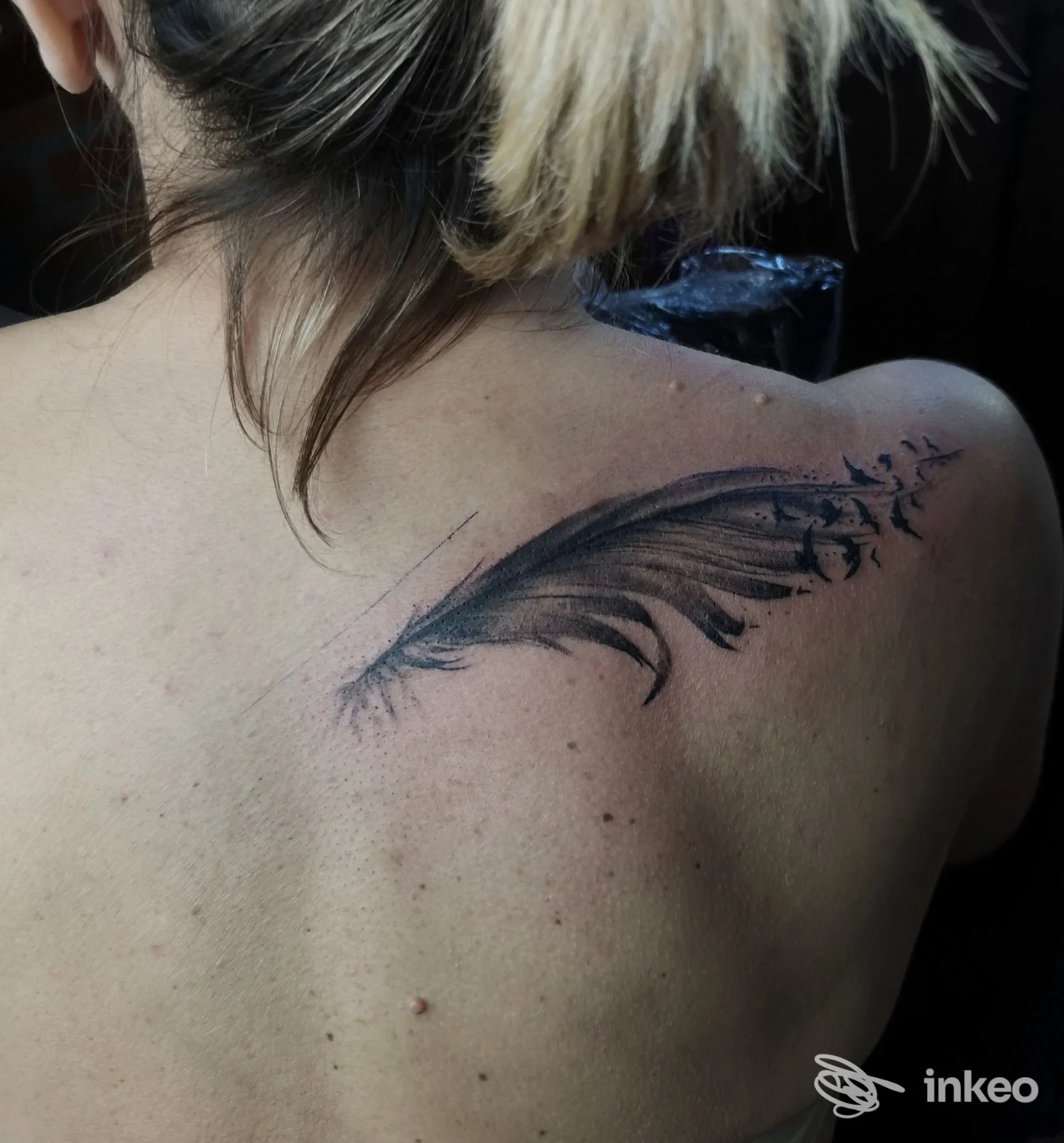 Tatuaggio a forma di piuma con piccoli uccelli sulla scapola, foto per Eudemonìa Tattoo Atelier a Sarzana.