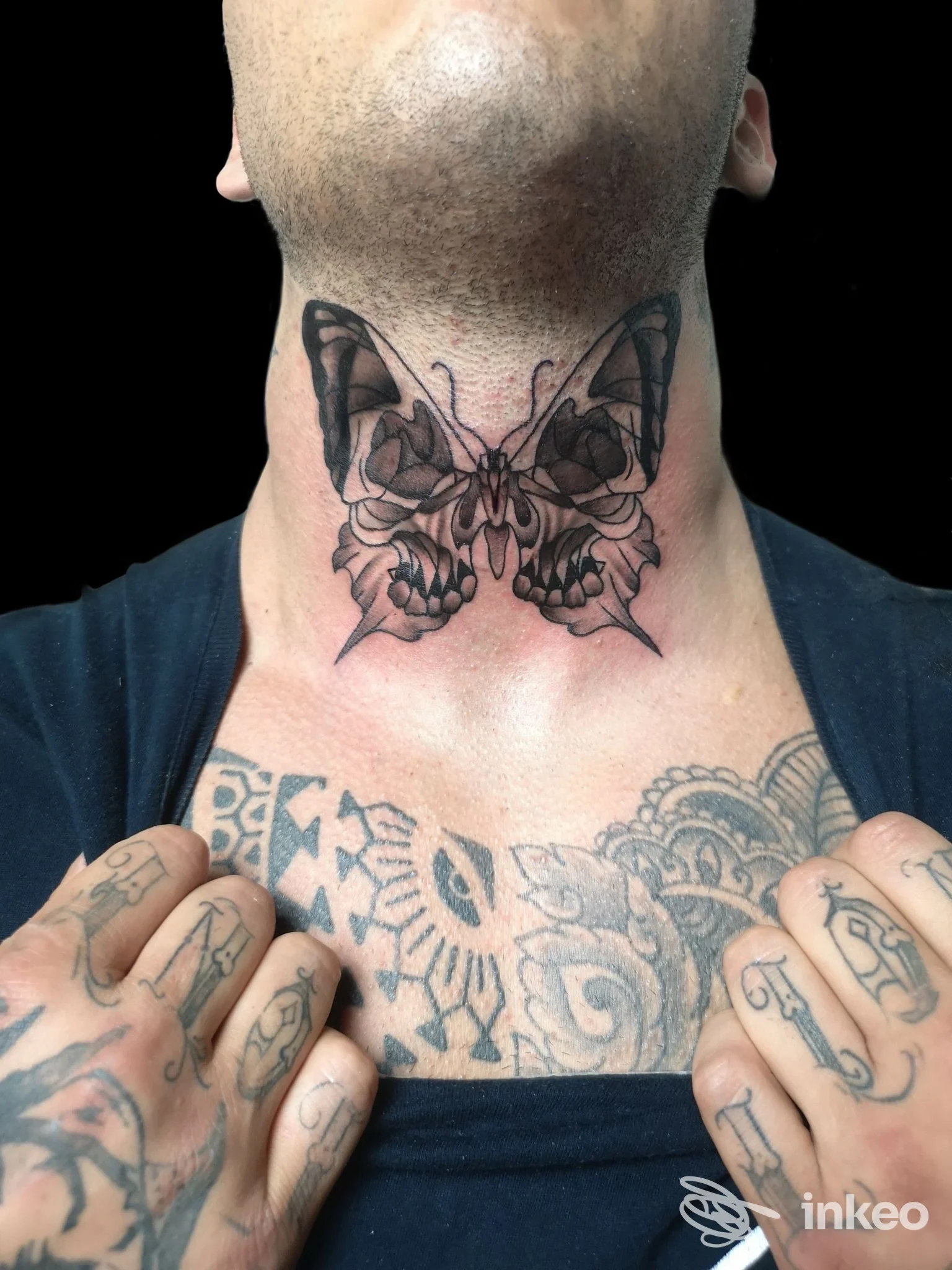 Tatuaggio farfalla in bianco e nero sulla gola, dettagli e sfumature visibili; immagine fornita da Eudemonìa Tattoo Atelier, Sarzana.