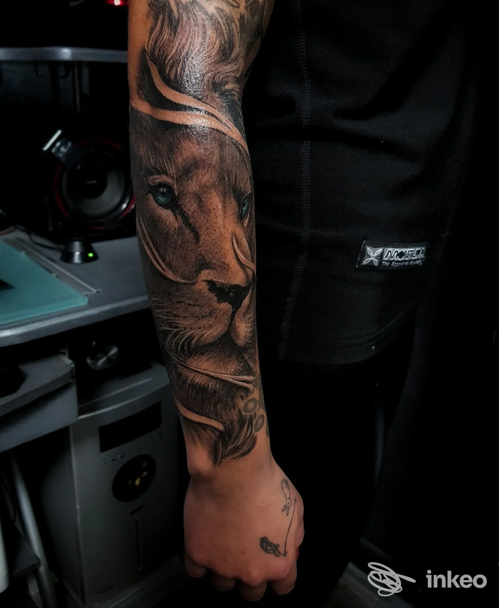 Foto ravvicinata di un tatuaggio realistico raffigurante un leone sull'avambraccio di un cliente, realizzato da Flo Tattoo a Chiavari.