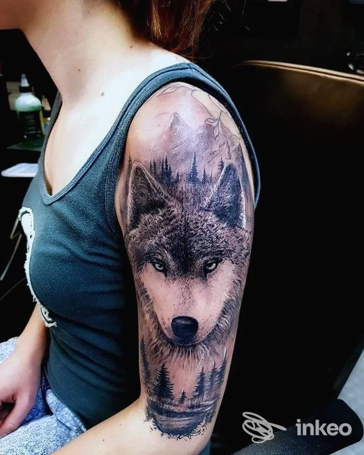 Tatuaggio realistico di un lupo sul braccio superiore, fotografato nello studio Flo Tattoo a Chiavari.