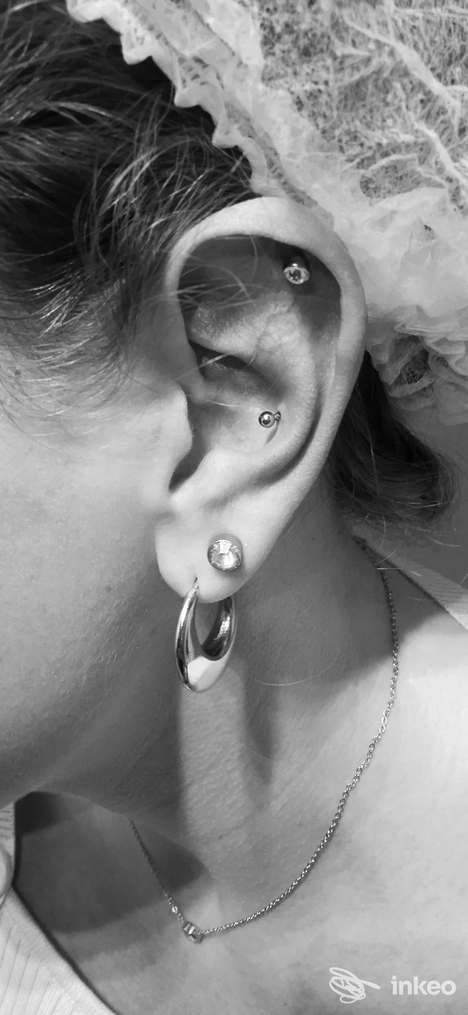Primo piano dell'orecchio con più piercing, Dream Of Trilli Dark piercing e tattoo, Genova.