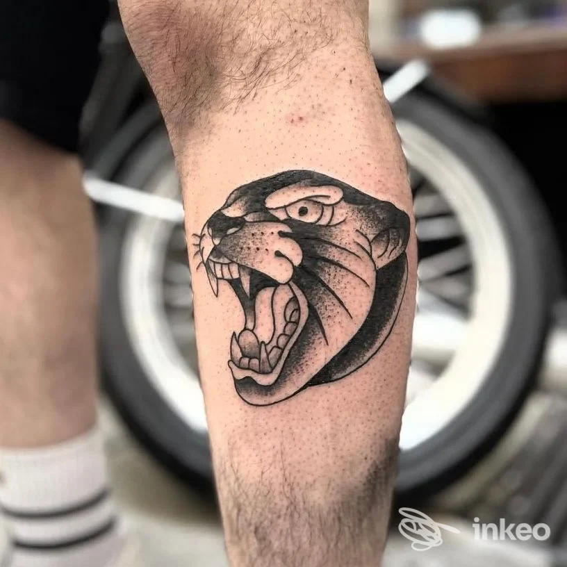 Tatuaggio a inchiostro nero di una testa di pantera sul polpaccio, lavoro pubblicato da Duman Tattoo Studio, Genova.