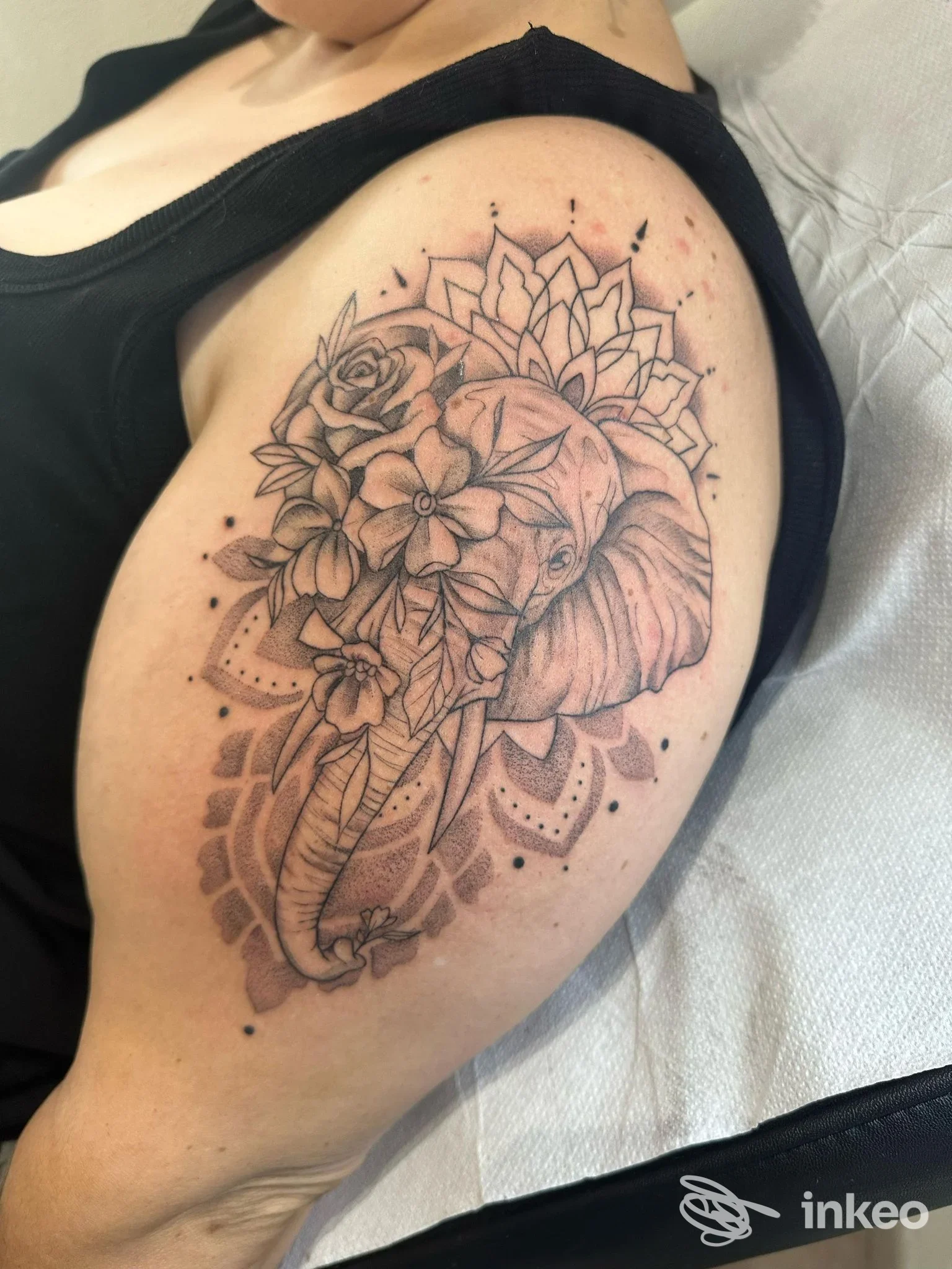 Tatuaggio a inchiostro nero su spalla con elefante e fiori, Francesca Accardo Tattoo Artist a Romito Magra.