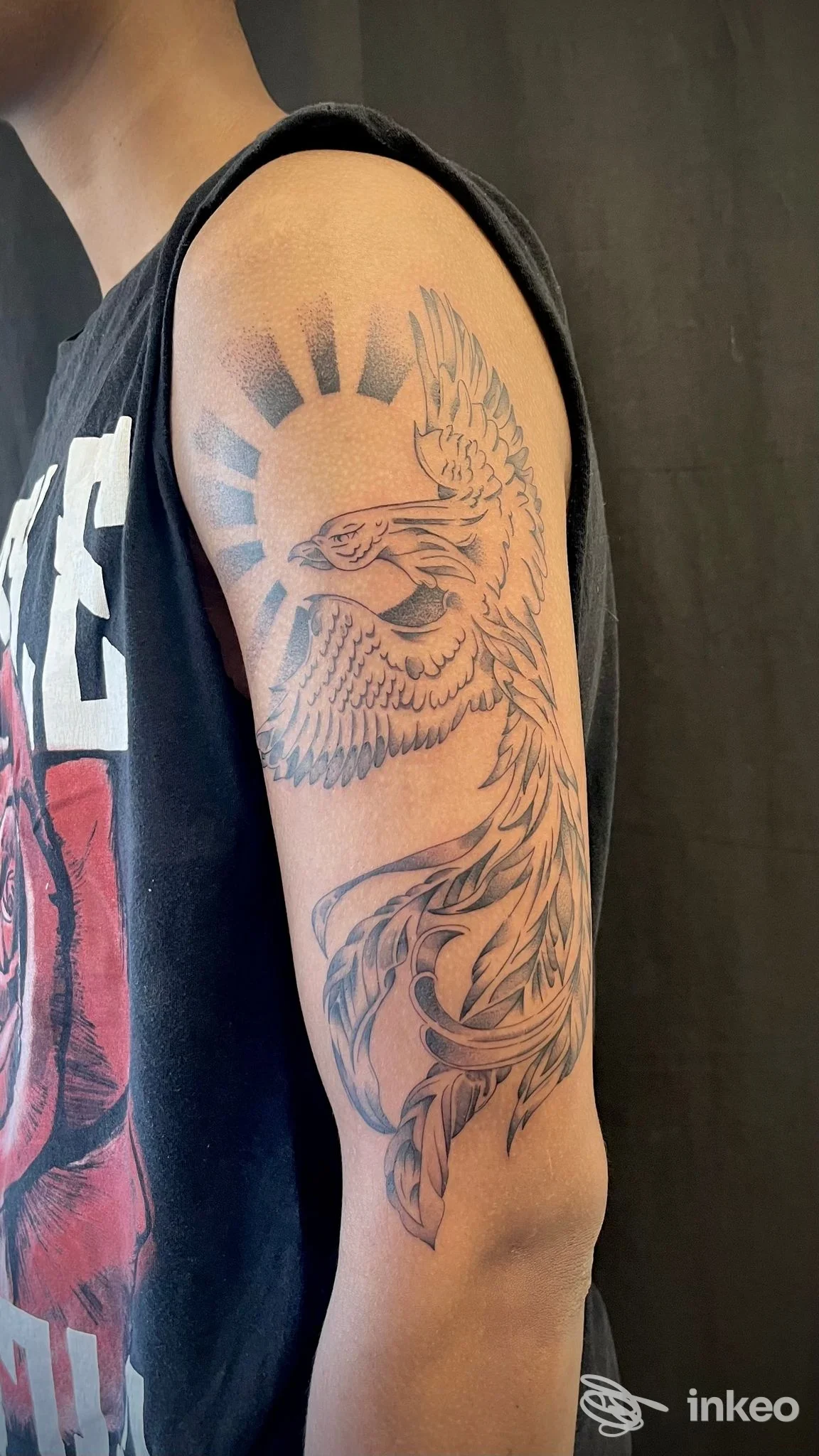 Tatuaggio a inchiostro nero di un uccello stilizzato sulla spalla e parte superiore del braccio, foto inviata da GM Art Tattoo, Genova.