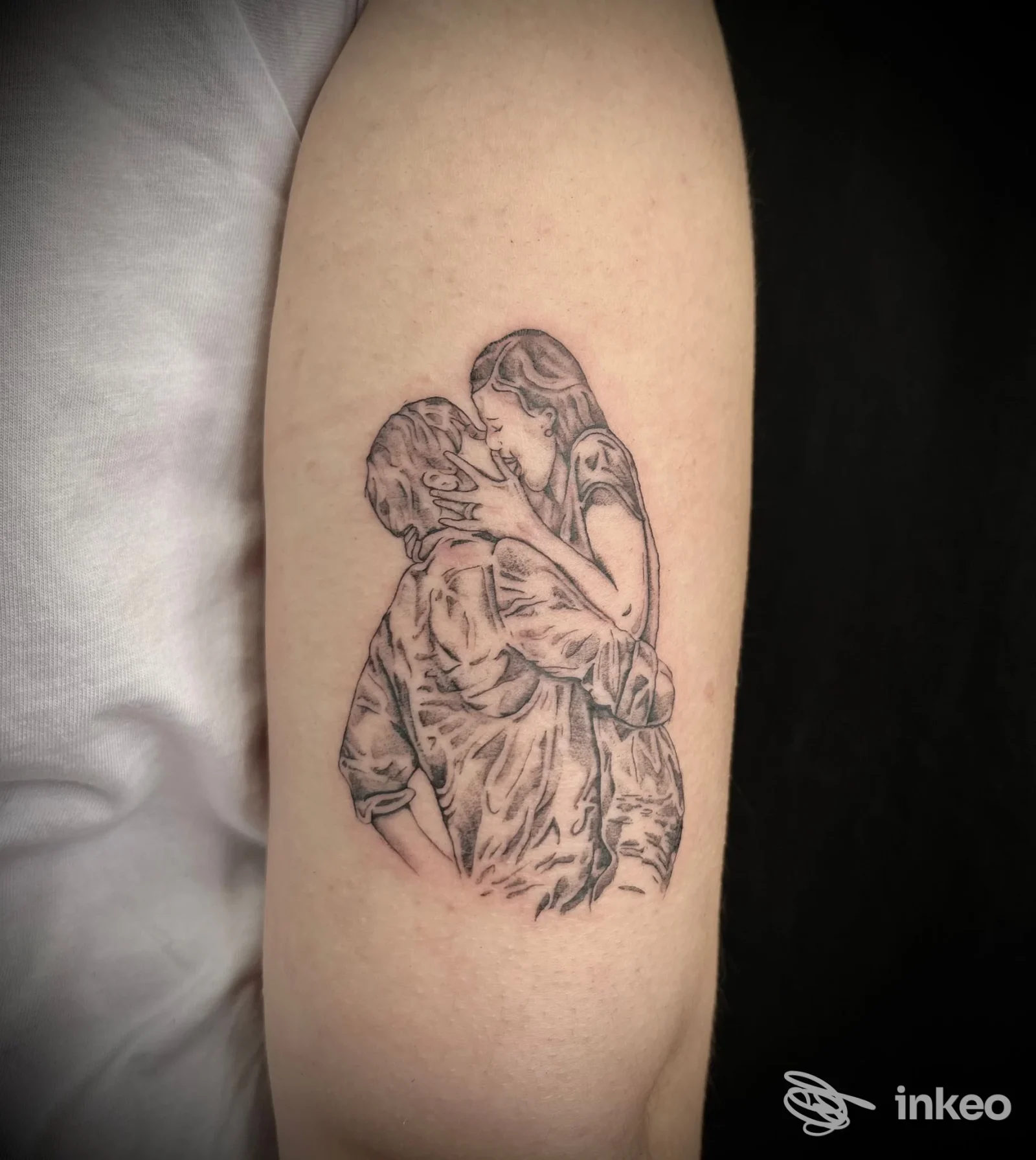 Tatuaggio a linee sottili di una coppia che si bacia sull'avambraccio, GM Art Tattoo, Genova.