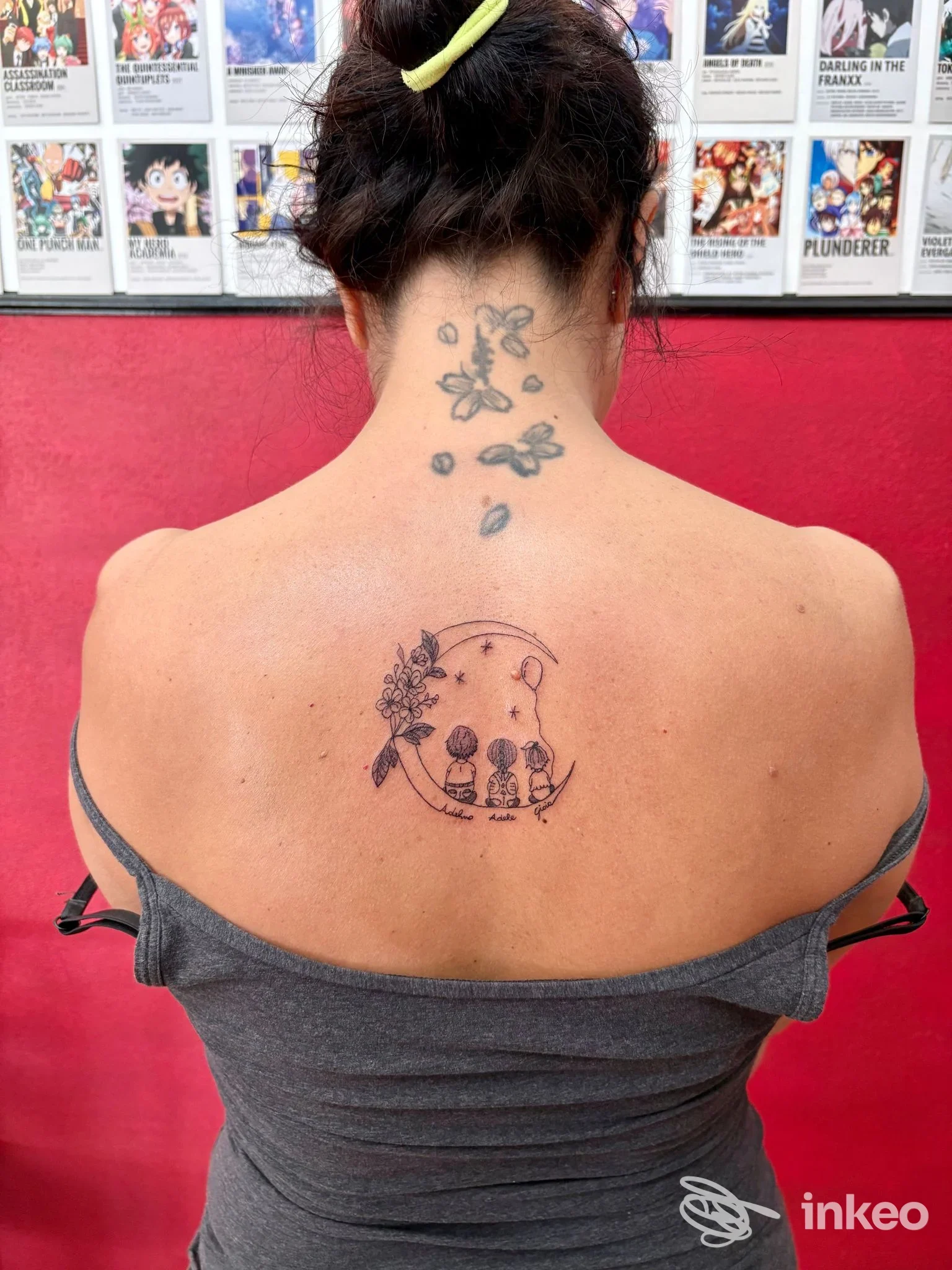 Tatuaggio sul centro della parte superiore della schiena con motivi floreali e tre figure stilizzate, foto inviata da Ghoster Tattoo, Chiavari.