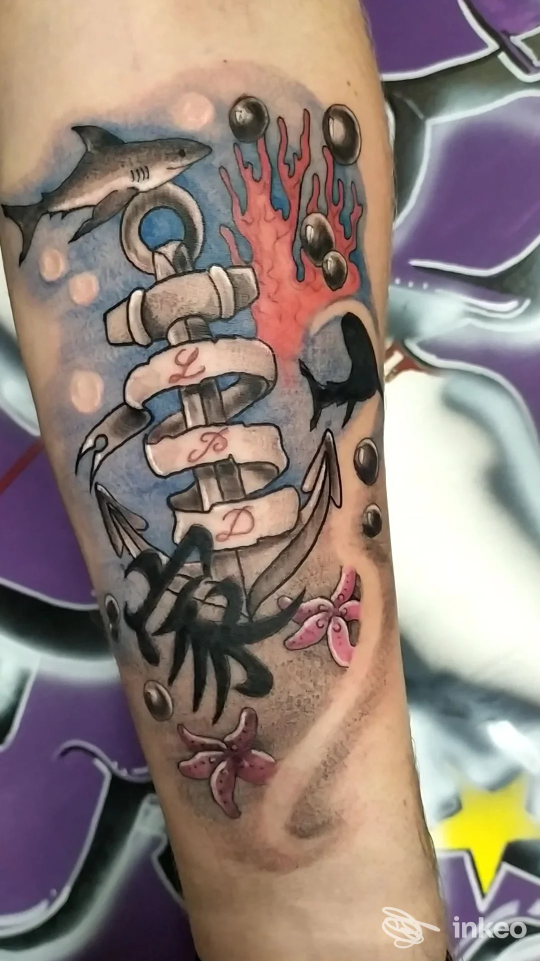 Tatuaggio su avambraccio con ancora, squalo e fiori — Gocce Proibite Tattoo Studio, Finale Ligure.