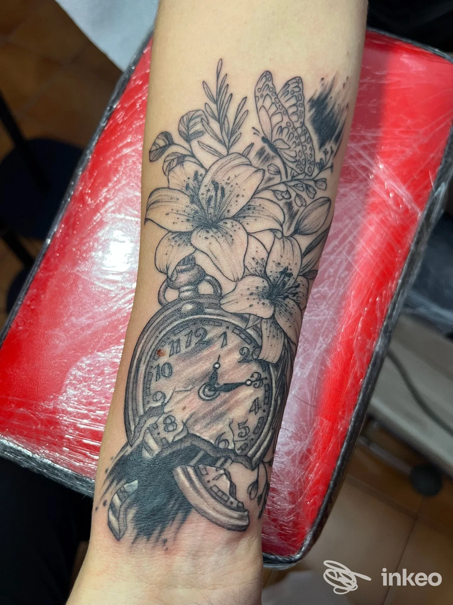Tatuaggio su avambraccio con orologio da tasca, fiori e farfalla — Jobba Tattoo Lab, Bordighera.