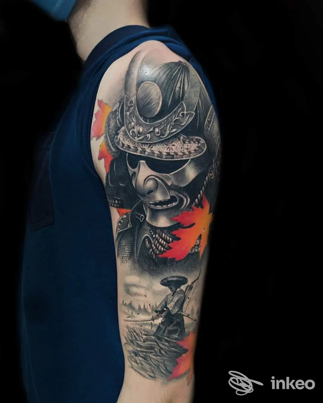 Tatuaggio a manica su braccio con maschera samurai in nero e grigio e foglie arancioni, immagine pubblicata da Kreiontattoo di William Tronchi, Gattorna.