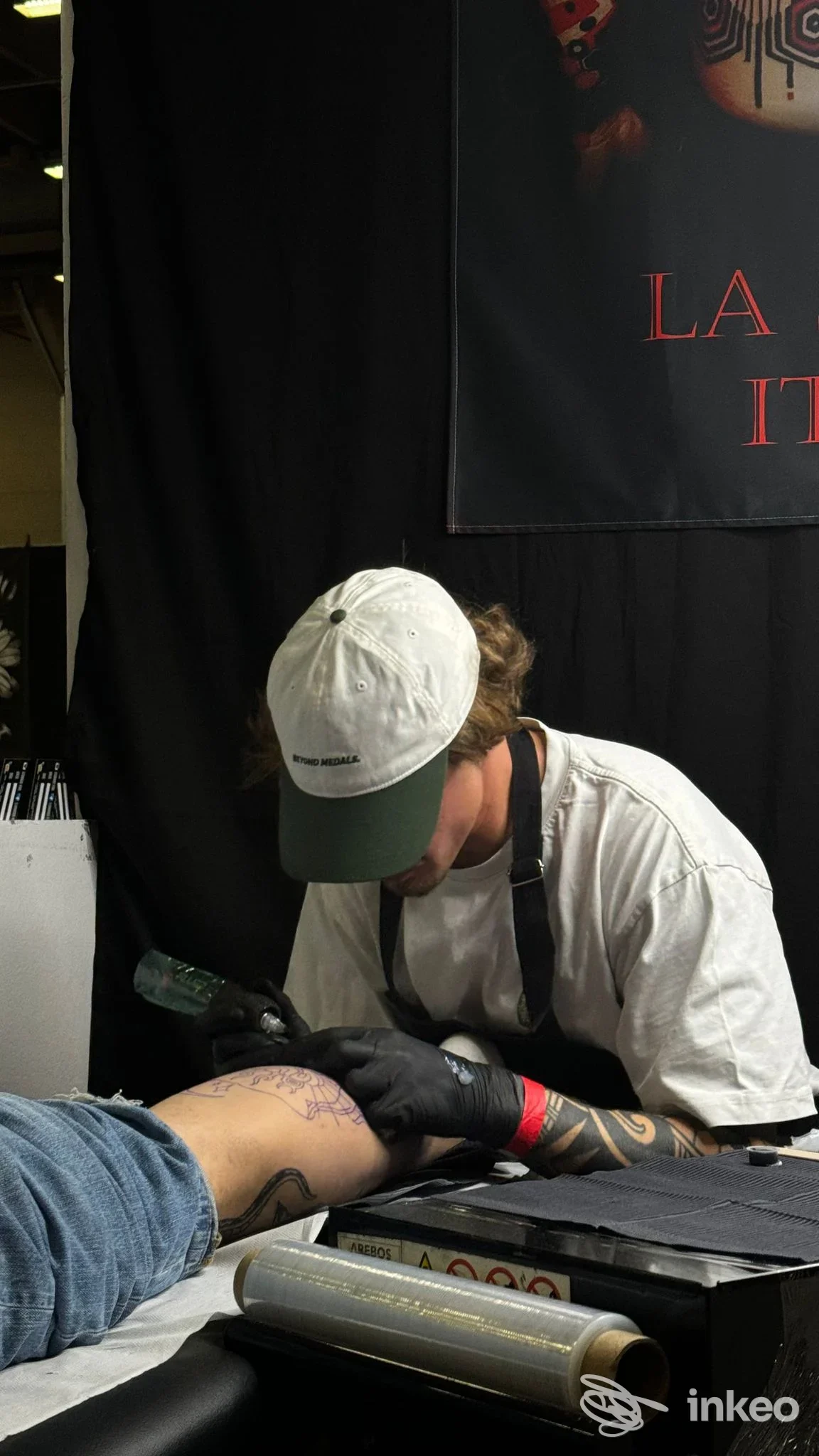 Tatuatore Leonard Vink al lavoro su una gamba in studio a La Spezia, dettaglio del processo di inchiostrazione.