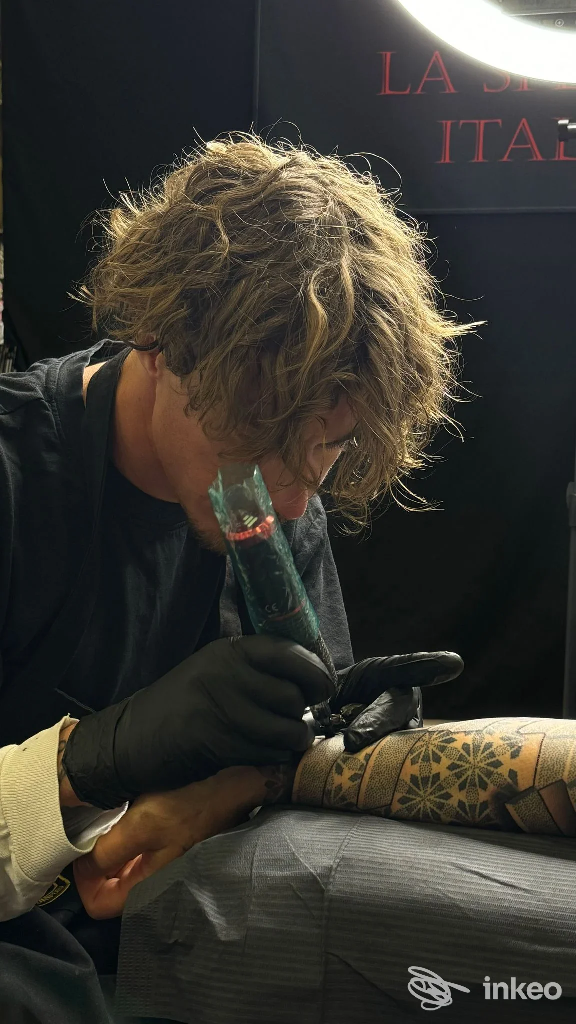 Tattoo in corso sull'avambraccio con motivi geometrici, artista al lavoro nello studio Leonard Vink Tattoo a La Spezia.