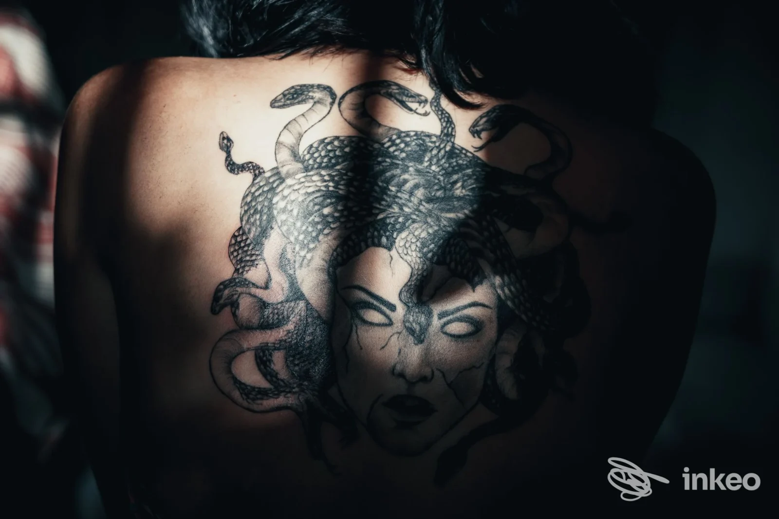 Grande tatuaggio Medusa in nero sulla parte superiore della schiena, foto inviata da La Perla Nera Tattoo Studio ad Arenzano.