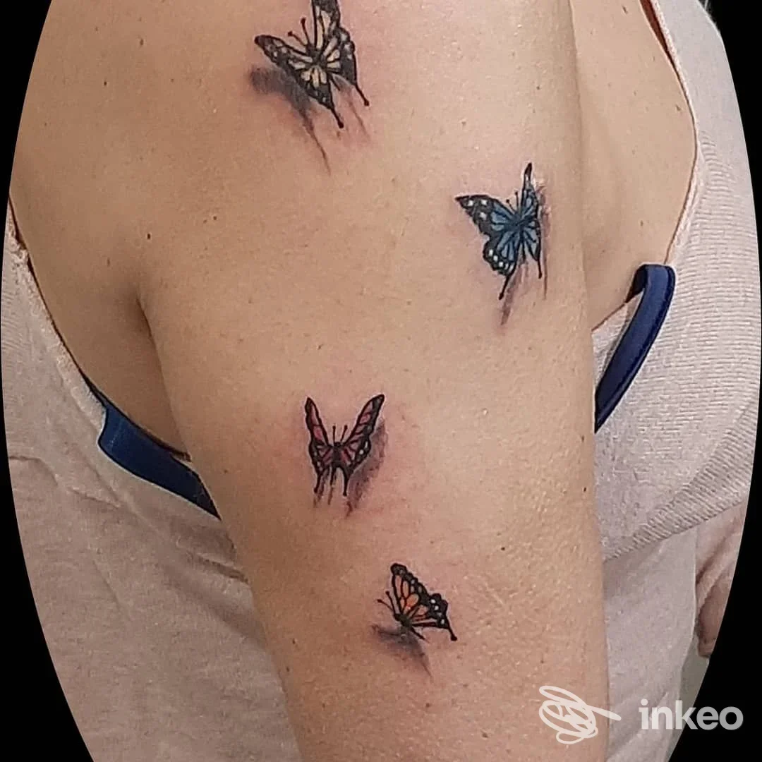 Più piccoli tatuaggi a farfalla colorati sul braccio superiore, foto fornita da La stella nera Tattoo, Genova.