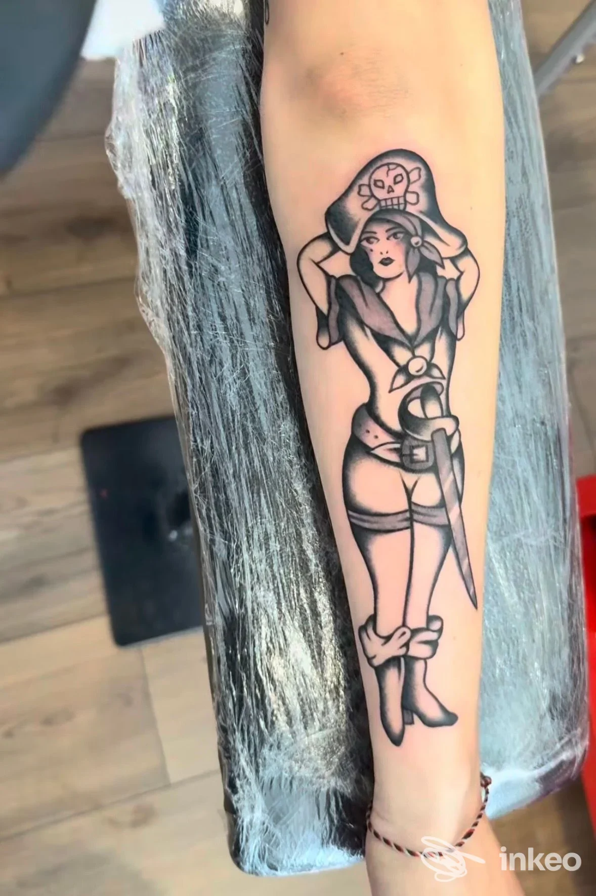 Tatuaggio in stile tradizionale di una donna-pirata sull'avambraccio, foto fornita da Lucky13 tattoo shop, Sestri Levante.