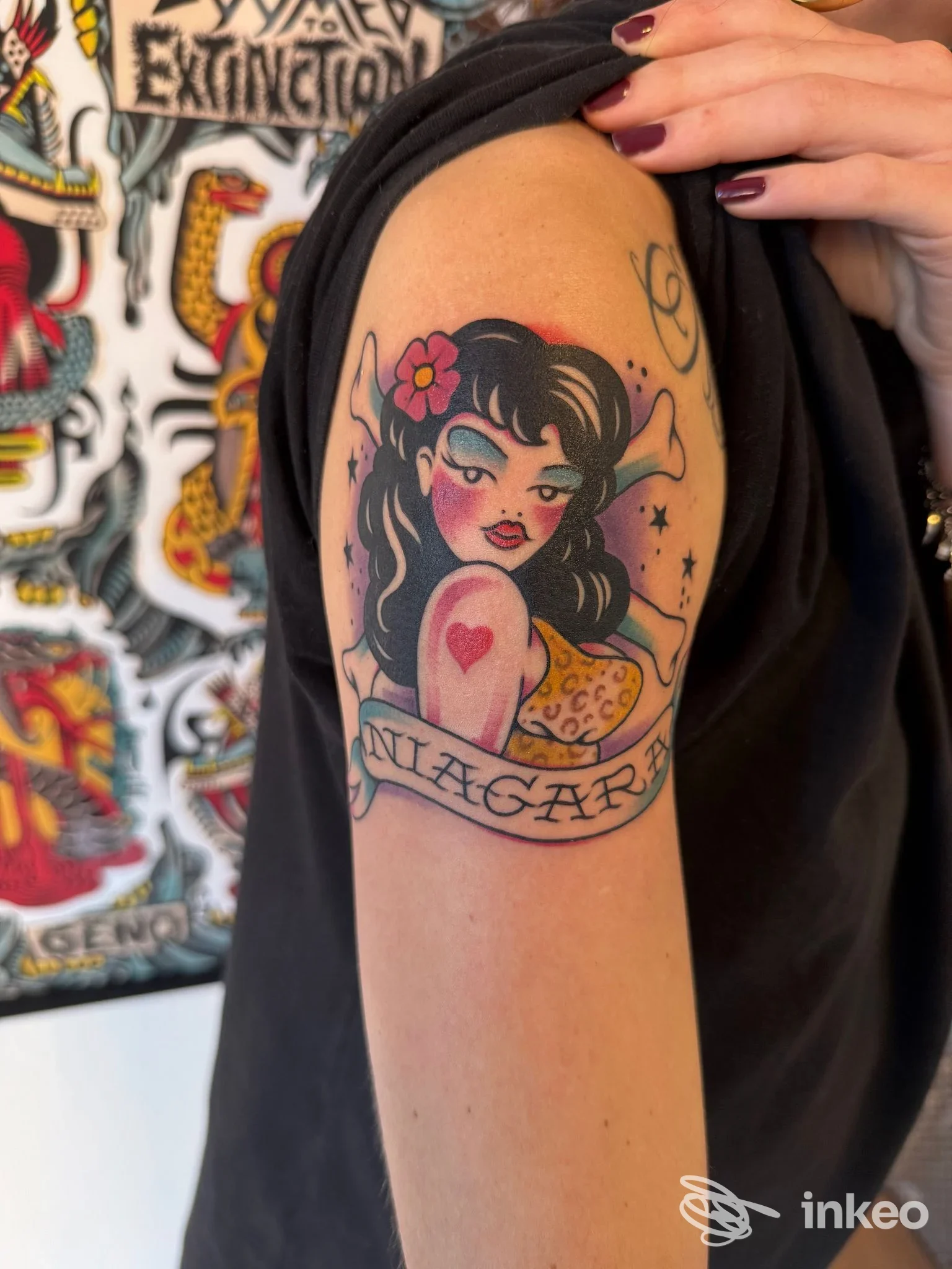 Tatuaggio old school a colori su braccio superiore con pin-up e cuore, fotografato presso Lucky13 tattoo shop a Sestri Levante.
