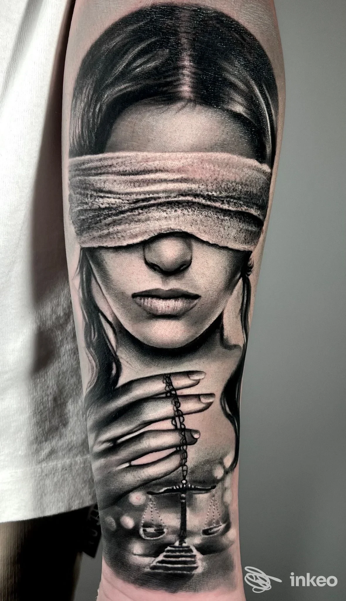 Tatuaggio realistico in bianco e nero su avambraccio: volto bendato e mano con rosario. MARCO GIOFFRÉ - mark ink tattoo, Genova.