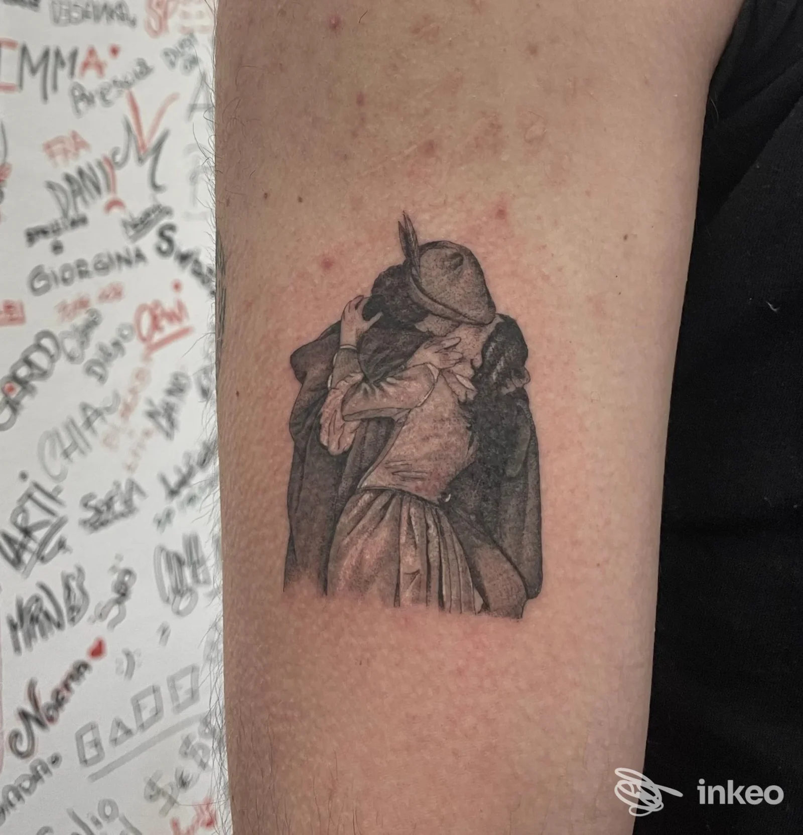 Tatuaggio in nero su avambraccio interno raffigurante due figure che si abbracciano, foto fornita da Maison René Tattoo, La Spezia.