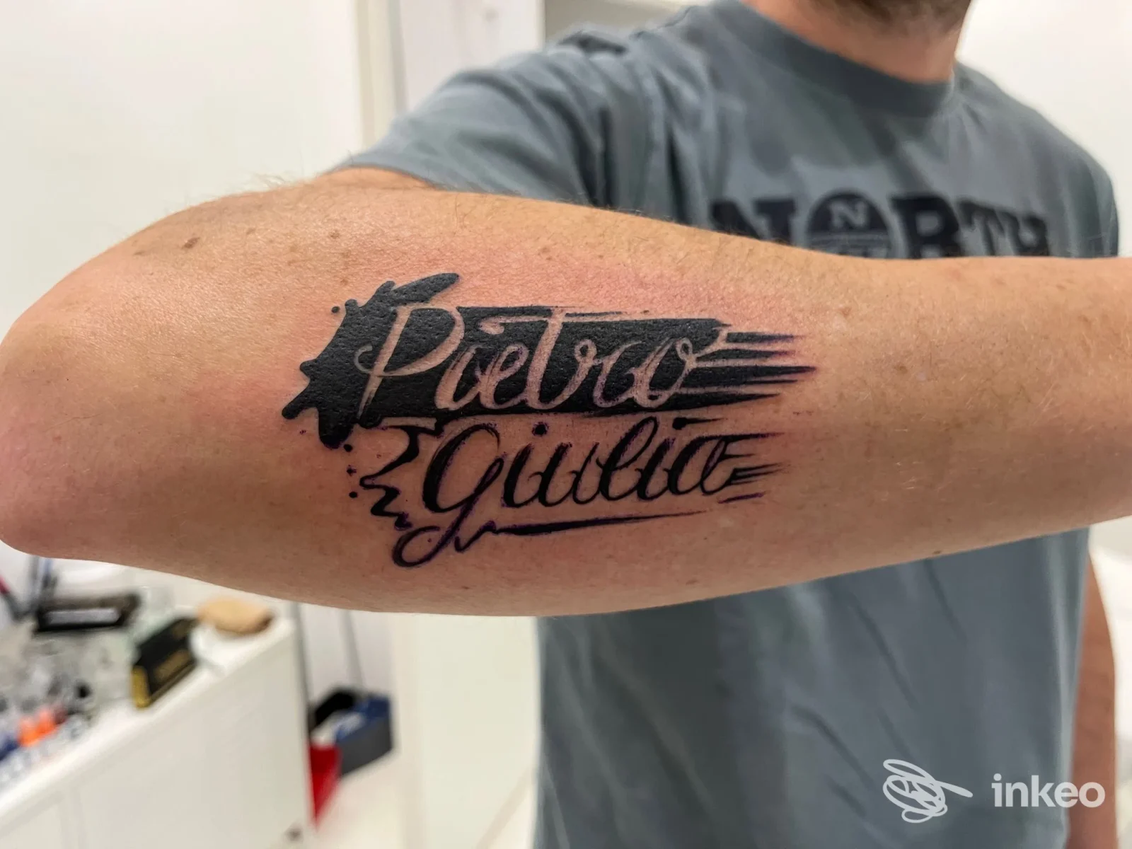 Tatuaggio lettering nero 'Pietro Giulia' sull'avambraccio, foto eseguita in studio Lus Ideas And Tattoos a Ronco Scrivia.