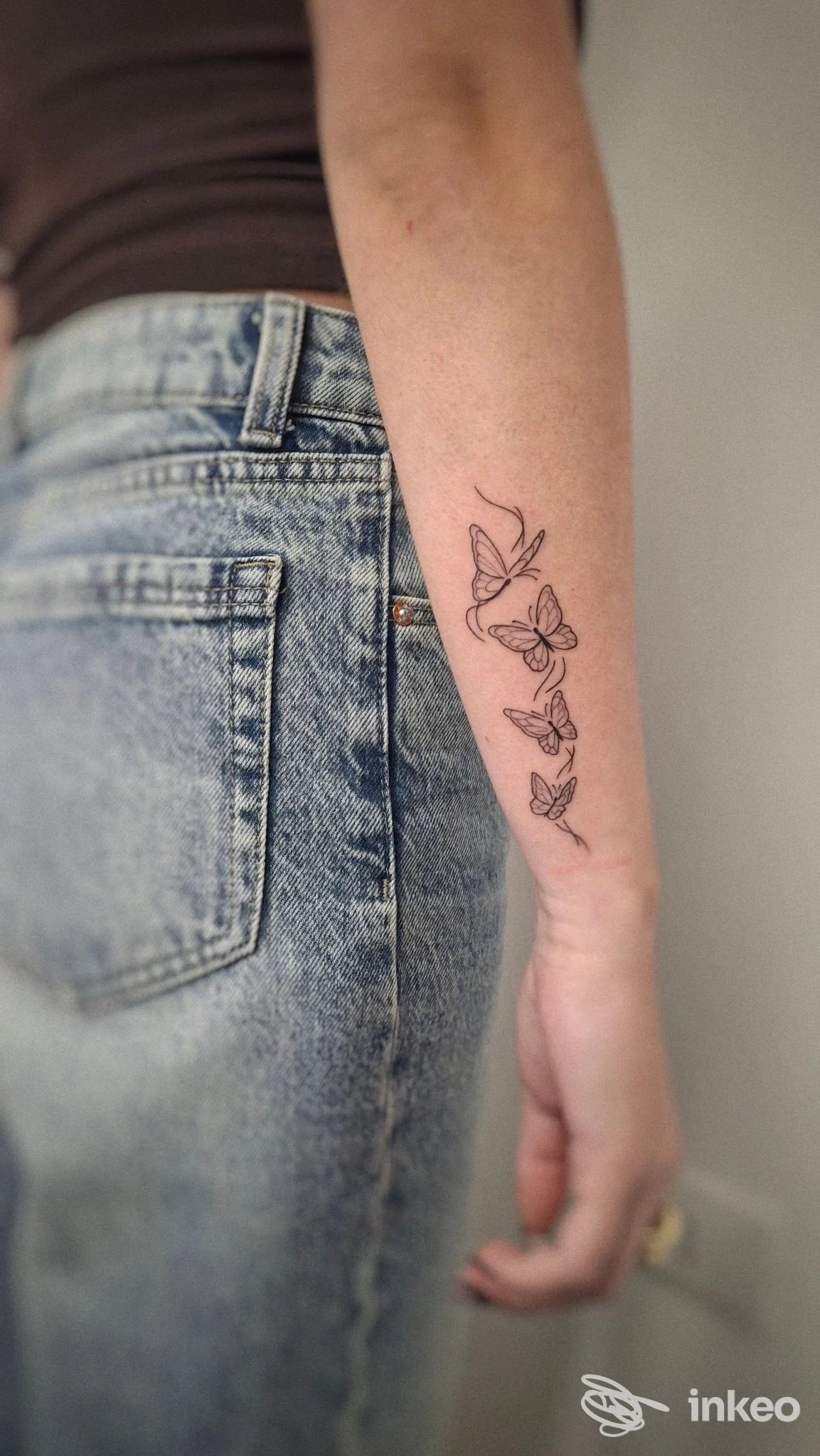 Avambraccio con tatuaggio lineare di farfalle realizzato da Miriaddormento Tattoo Studio a Chiavari, foto verticale inquadratura sul braccio.