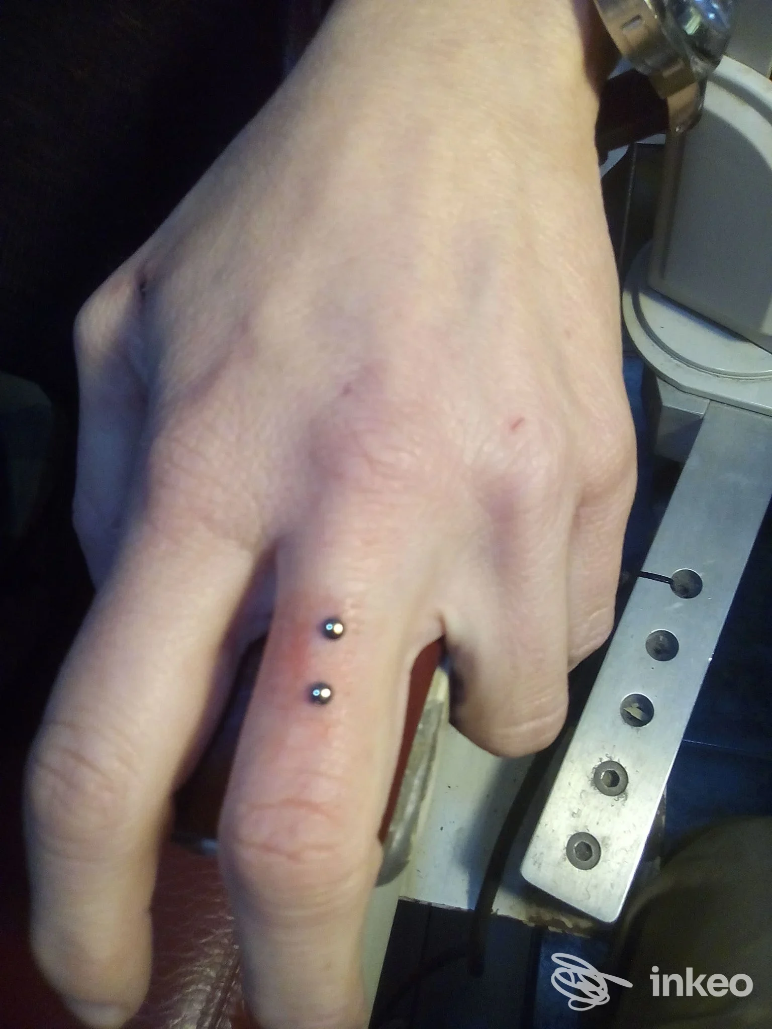 Piercing superficiale con due sfere sul lato di un dito, foto da Moai Body Piercing, Genova.