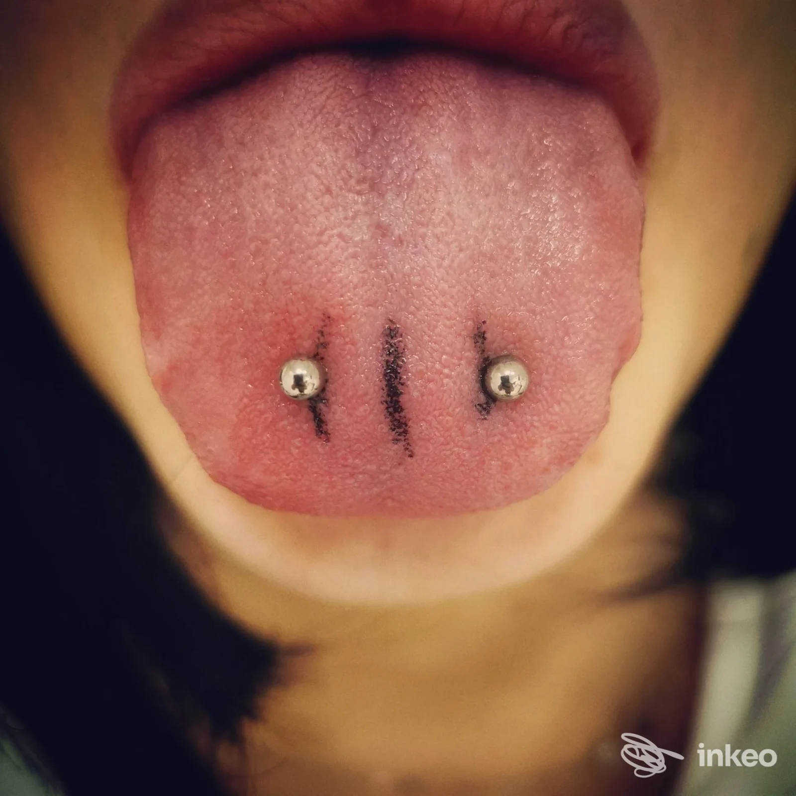 Primo piano di lingua con due piercing visibili, foto fornita da Mattia A. Tattooer a La Spezia.