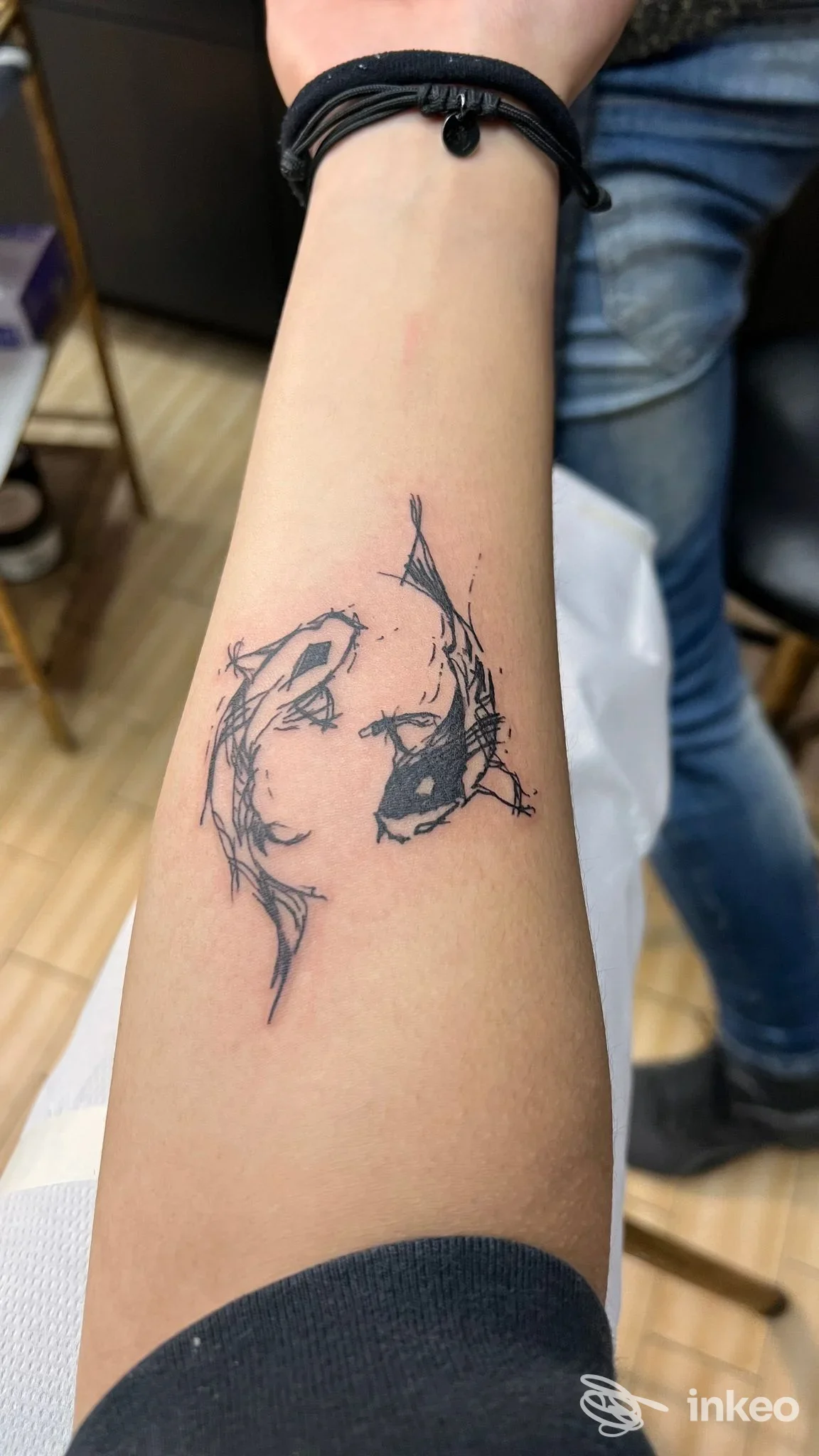Tatuaggio nero stilizzato di due figure intrecciate sull'avambraccio, foto inviata da Mattia A. Tattooer, La Spezia.