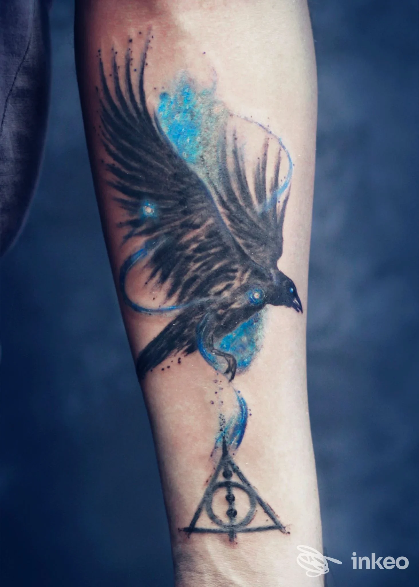 Tatuaggio su avambraccio con corvo in volo e dettagli blu, Narciso Tattoo and Fine Art, Imperia.