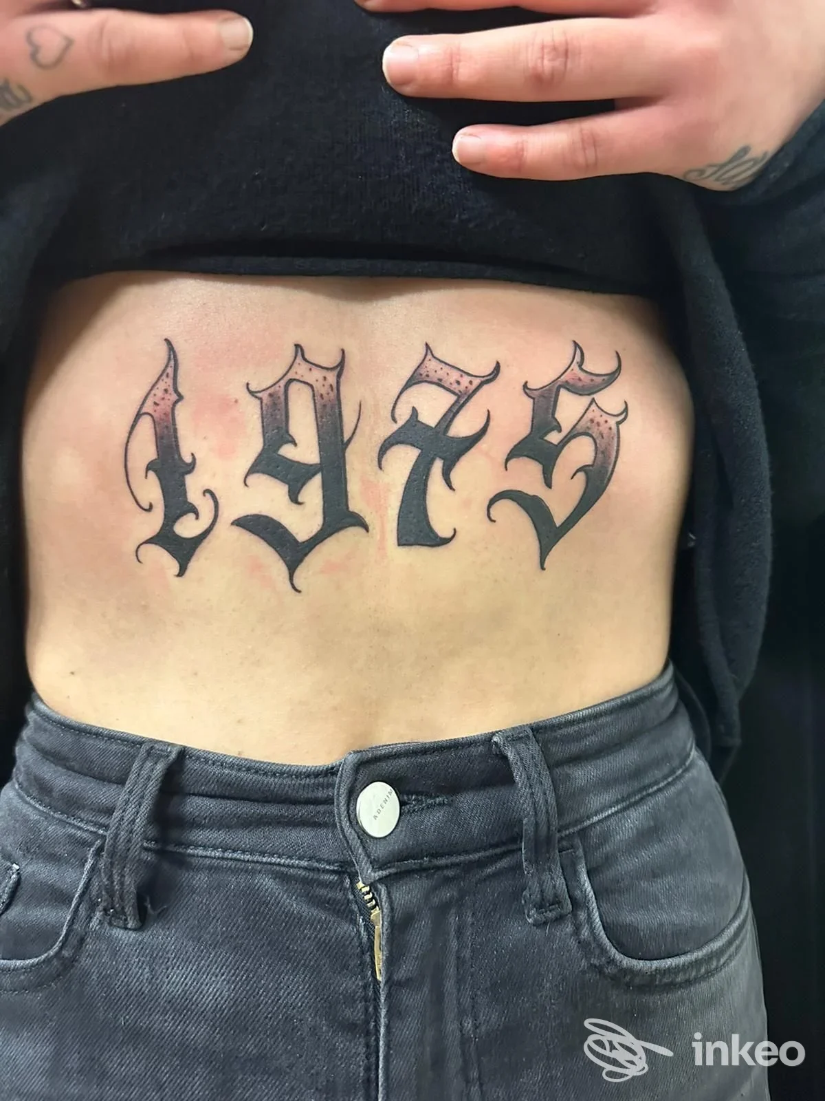 Tatuaggio numerico '1975' in stile Old English sul basso ventre, foto fornita da OLD&FAST TATTOO INK Savona.