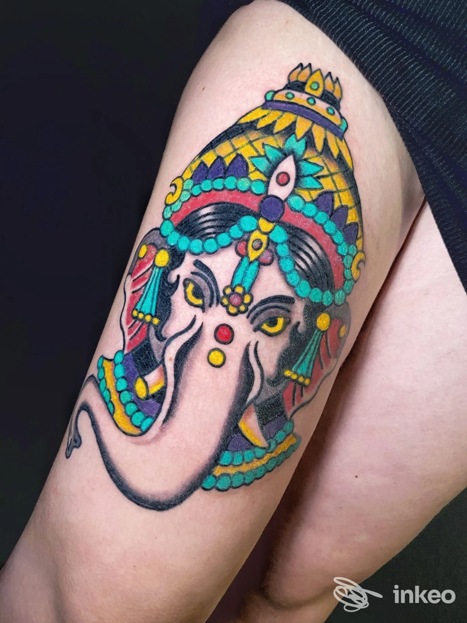 Tatuaggio colorato della testa di Ganesh sulla coscia, fotografato presso Old Town Tattoo Shop a Chiavari.