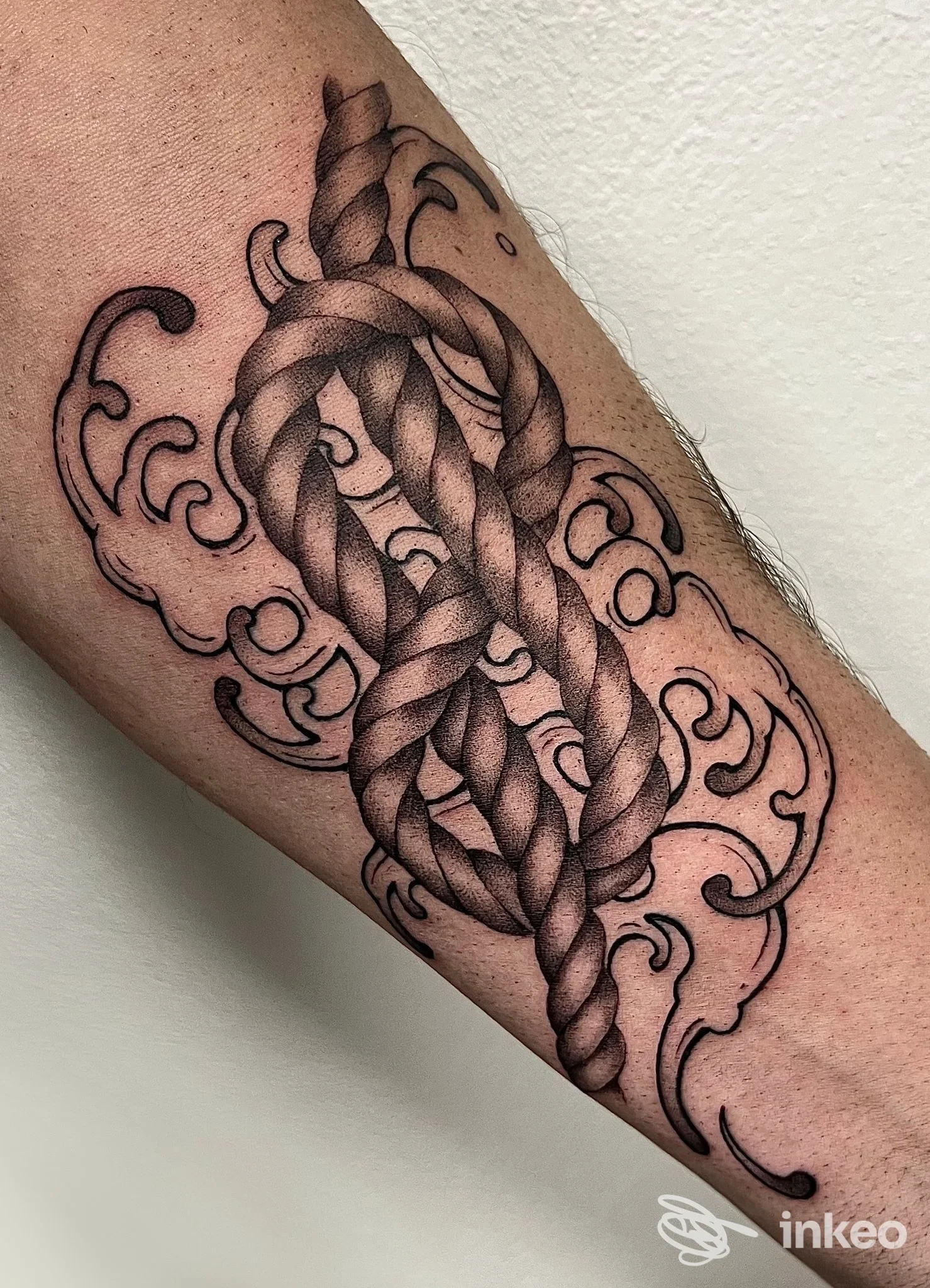 Tatuaggio a corda annodata con ornamenti su avambraccio, realizzato da Red Cat Tattoo & Art Gallery, Genova.