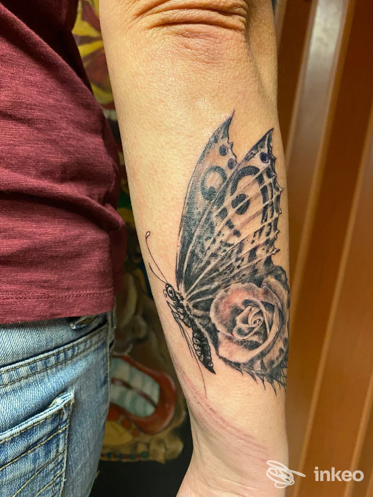 Tatuaggio di farfalla e rosa sull'avambraccio eseguito da Pejo Tattoo, Genova.