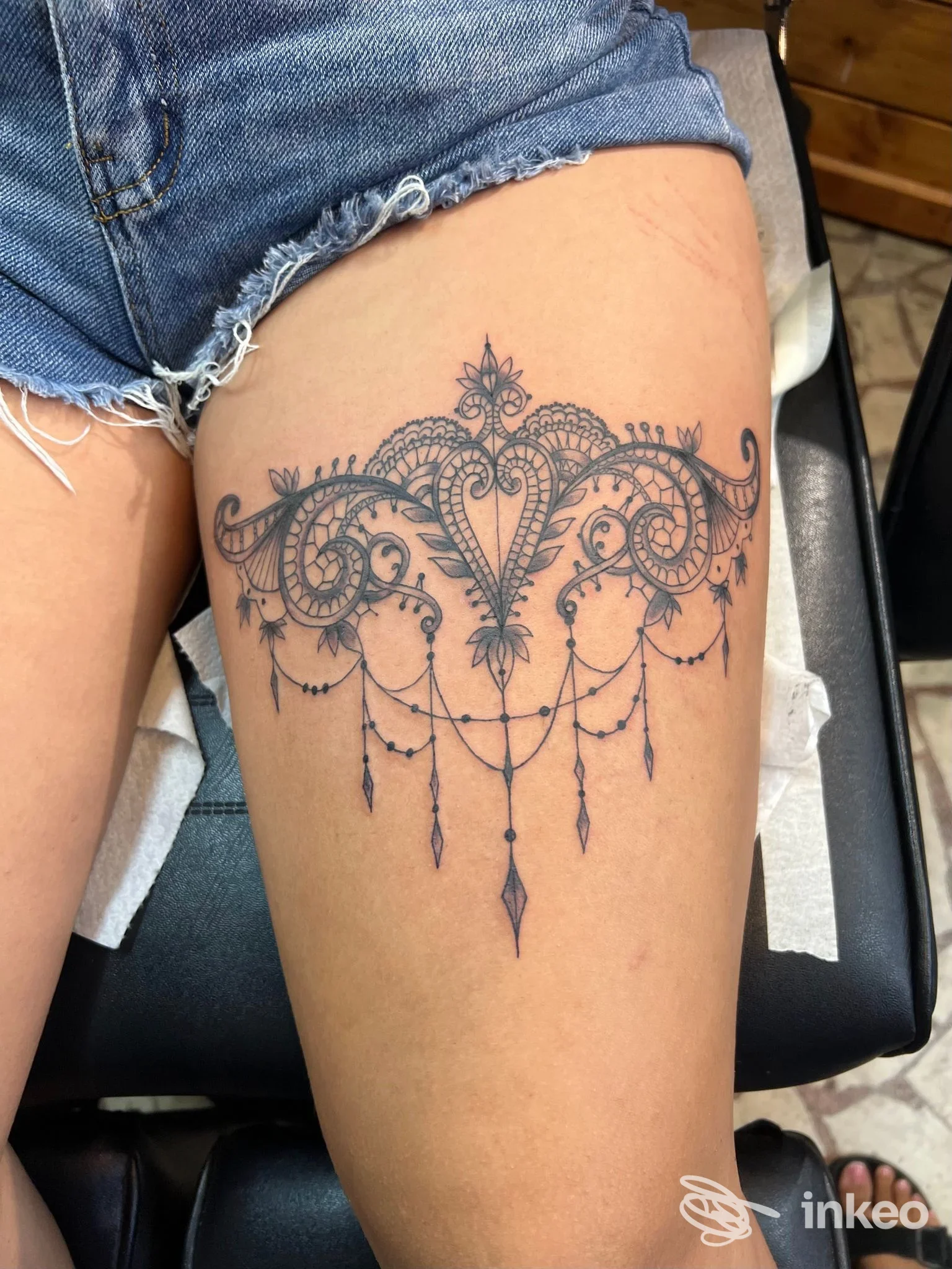 Tatuaggio ornamentale in bianco e nero sulla coscia realizzato da Rossini Tattoo, La Spezia.