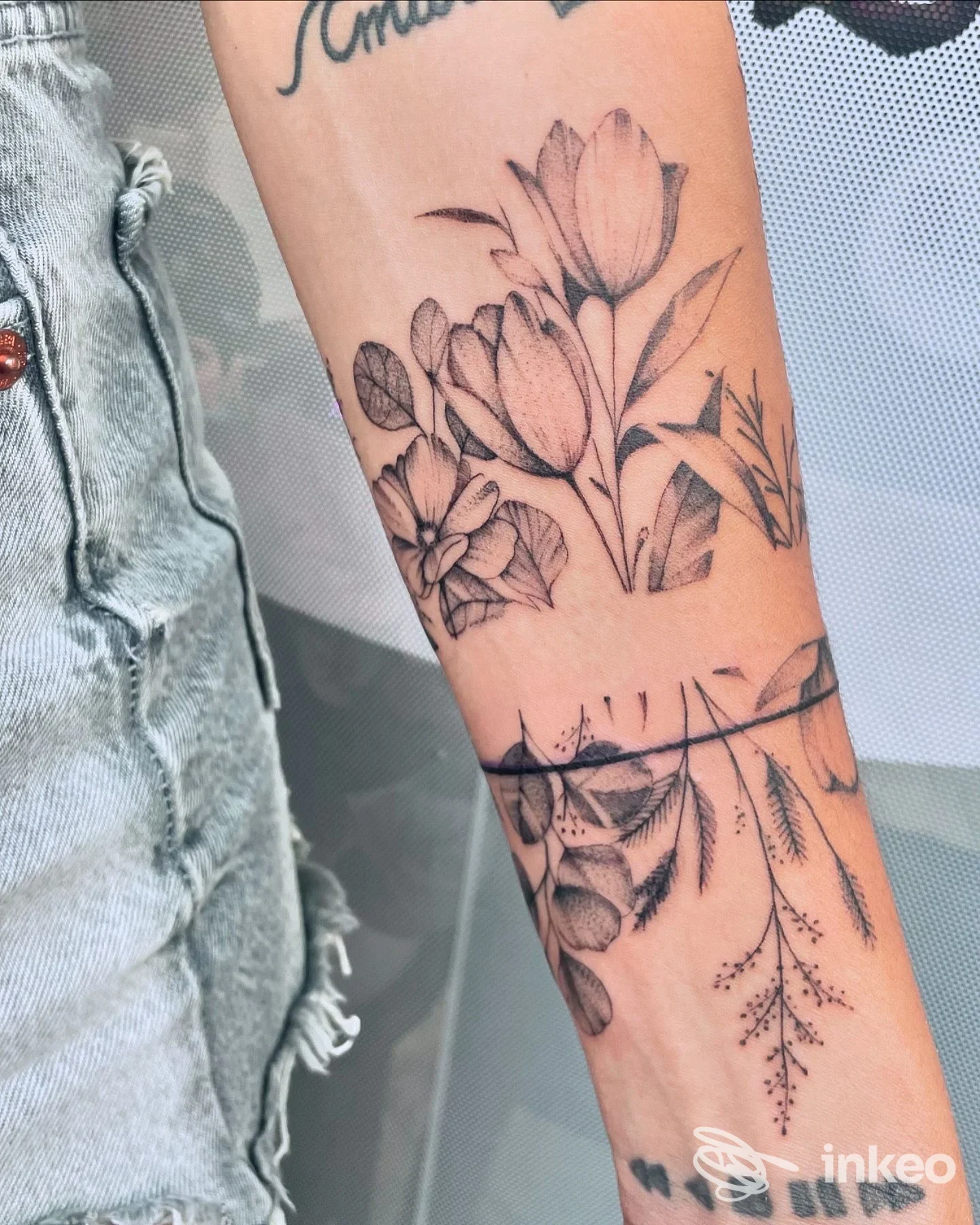 Tatuaggio floreale in bianco e nero sull'avambraccio, realizzato da Pink Fluid Tattoo Studio ad Arenzano.