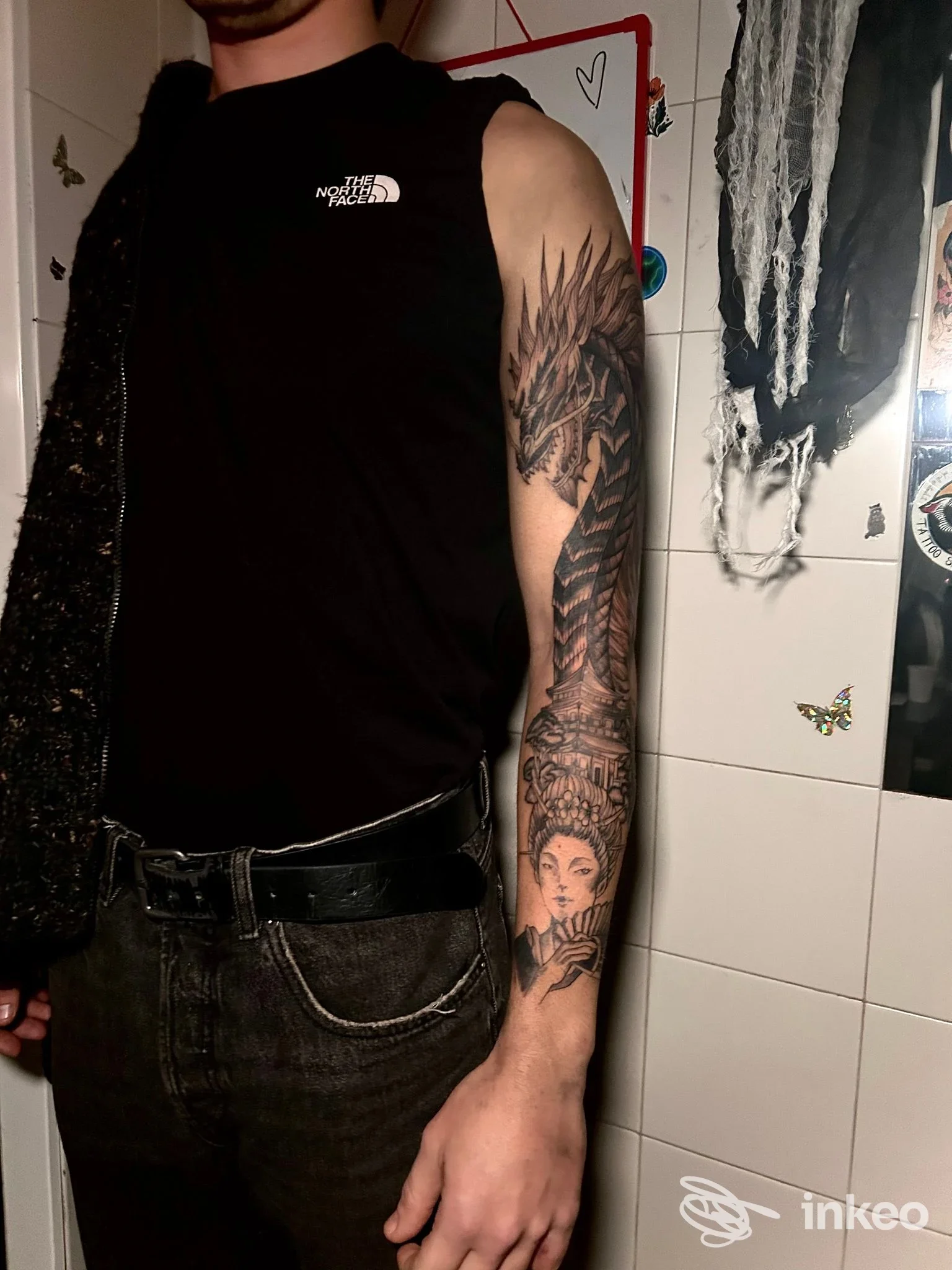 Tatuaggio a manica sul braccio sinistro con drago e figura femminile, foto fornita da Roxy Art Tattoo, Genova.