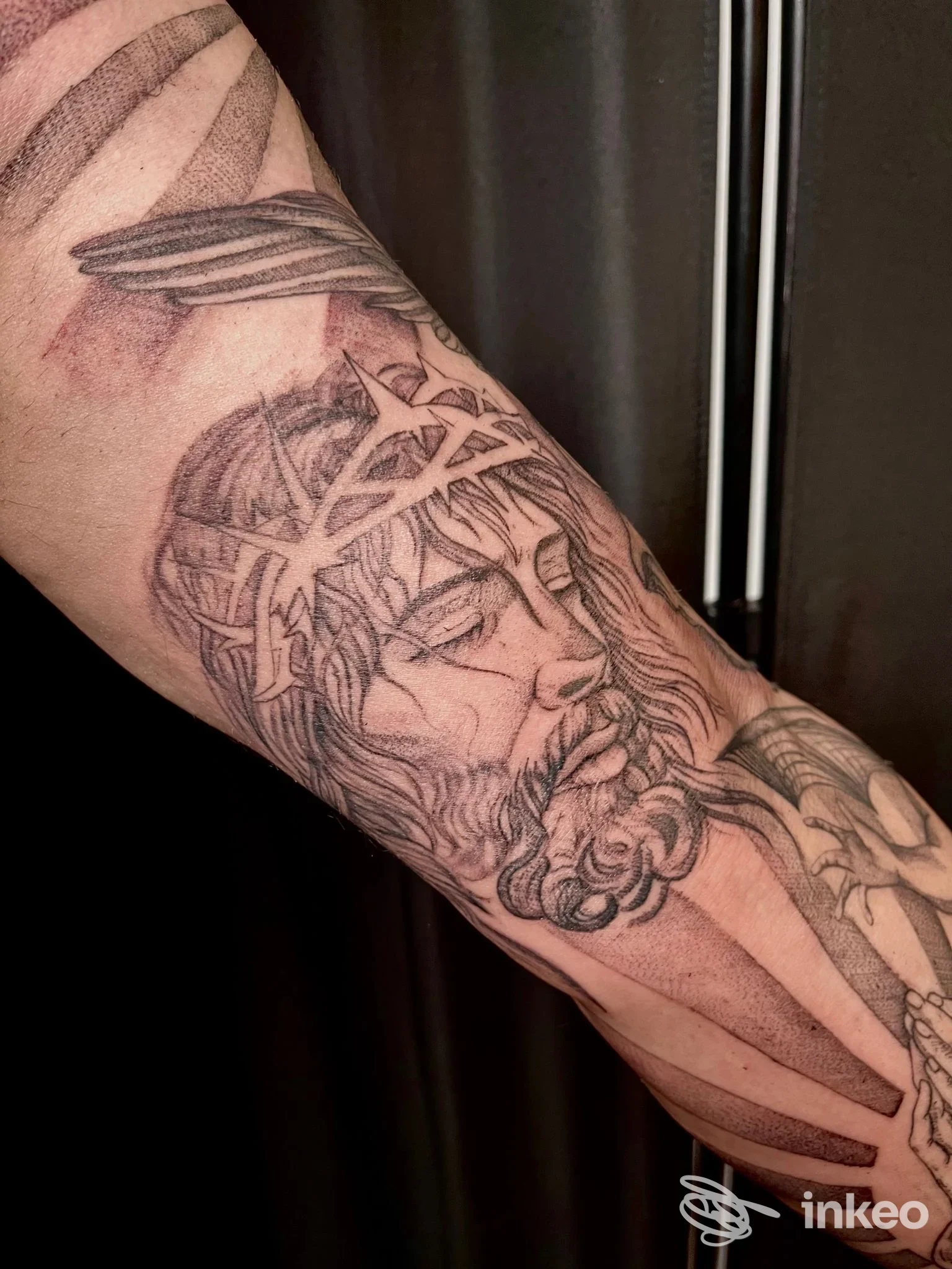 Tatuaggio sul avambraccio raffigurante un volto con corona di spine, foto fornita da Roxy Art Tattoo, Genova.
