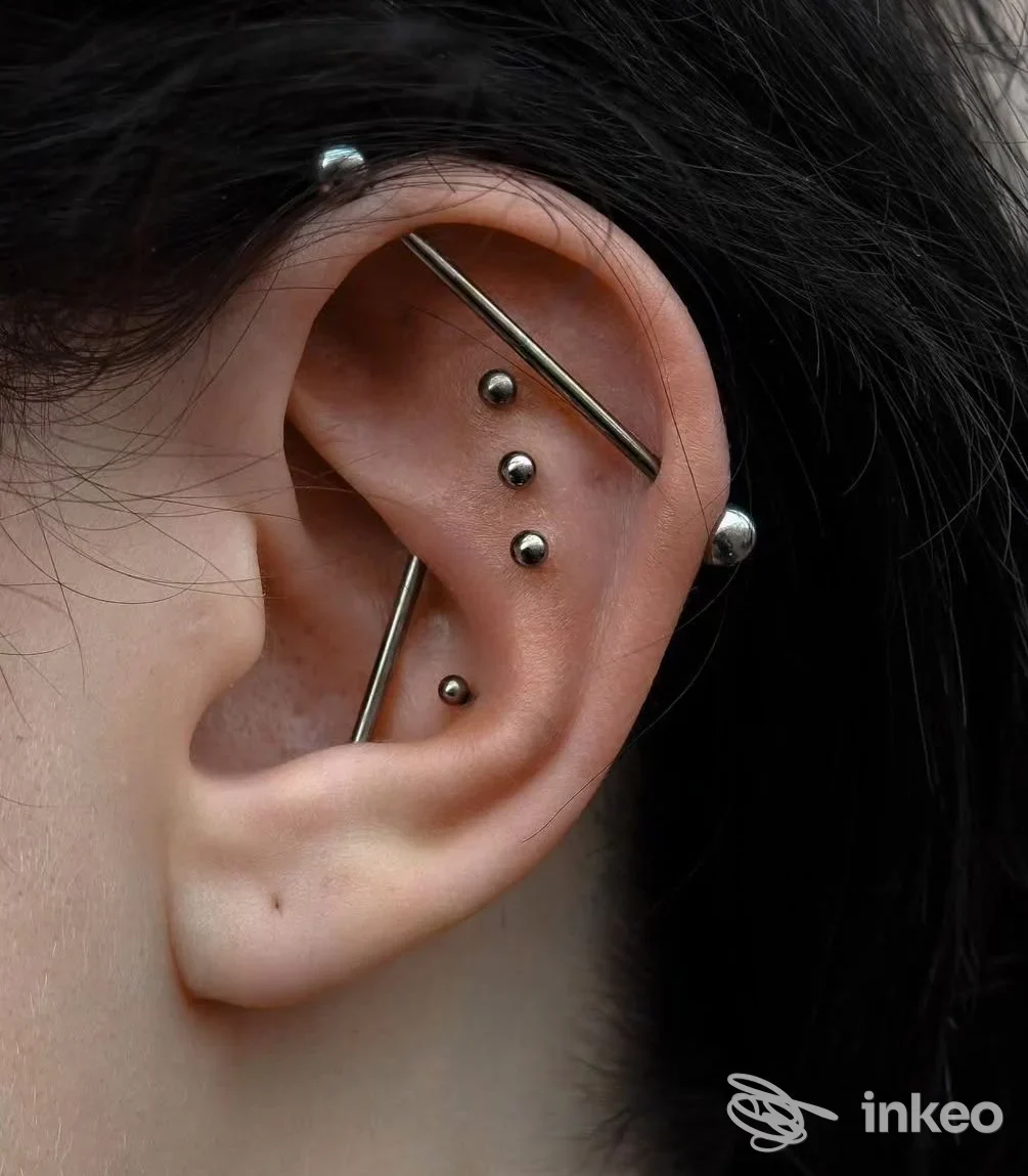 Primo piano di un orecchio con multipli piercing in metallo, Tattoo & Piercing il giardino degli inchiostri, Castelnuovo Magra.