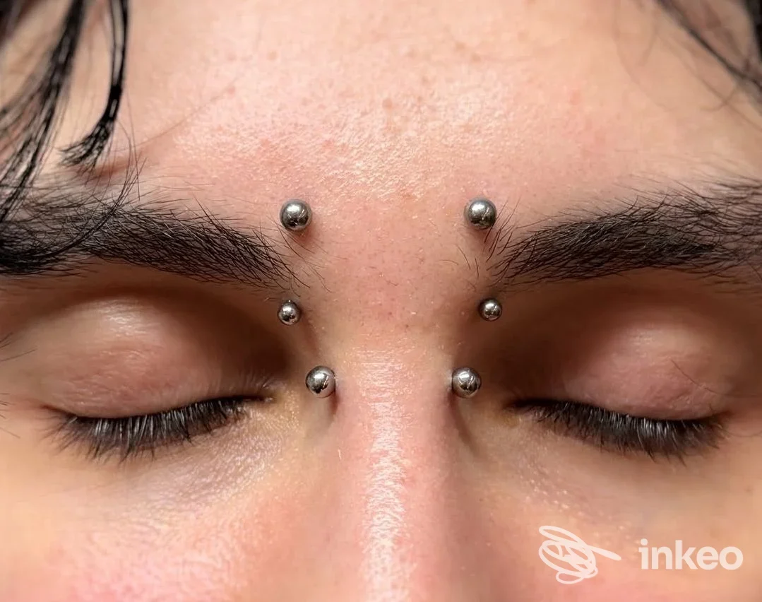 Primo piano di piercing multipli sul ponte nasale, eseguiti presso Tattoo & Piercing il giardino degli inchiostri a Castelnuovo Magra.