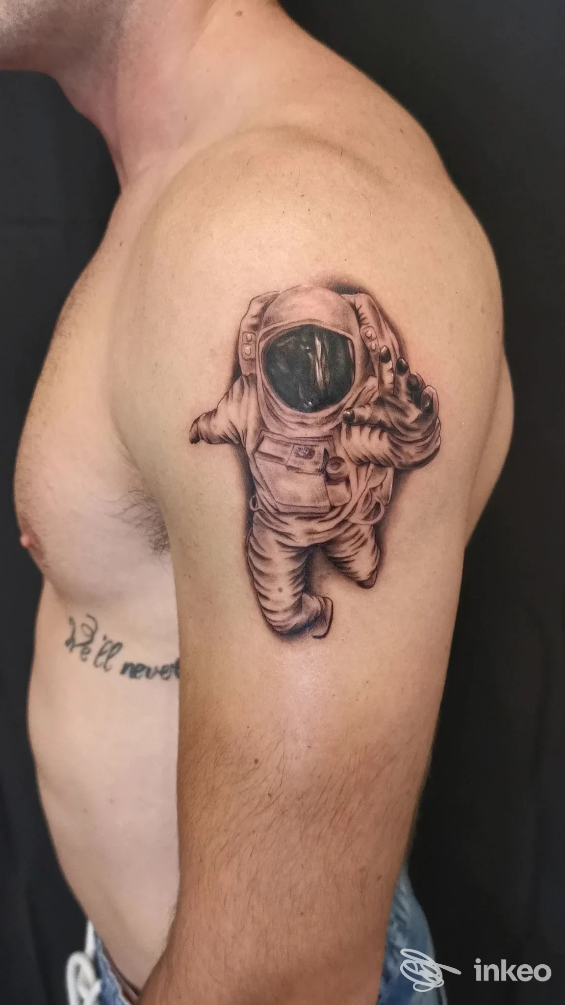 Tatuaggio realistico di un astronauta in bianco e nero sul deltoide sinistro, foto da THE EXECUTIVE TATTOO STUDIO, Genova.