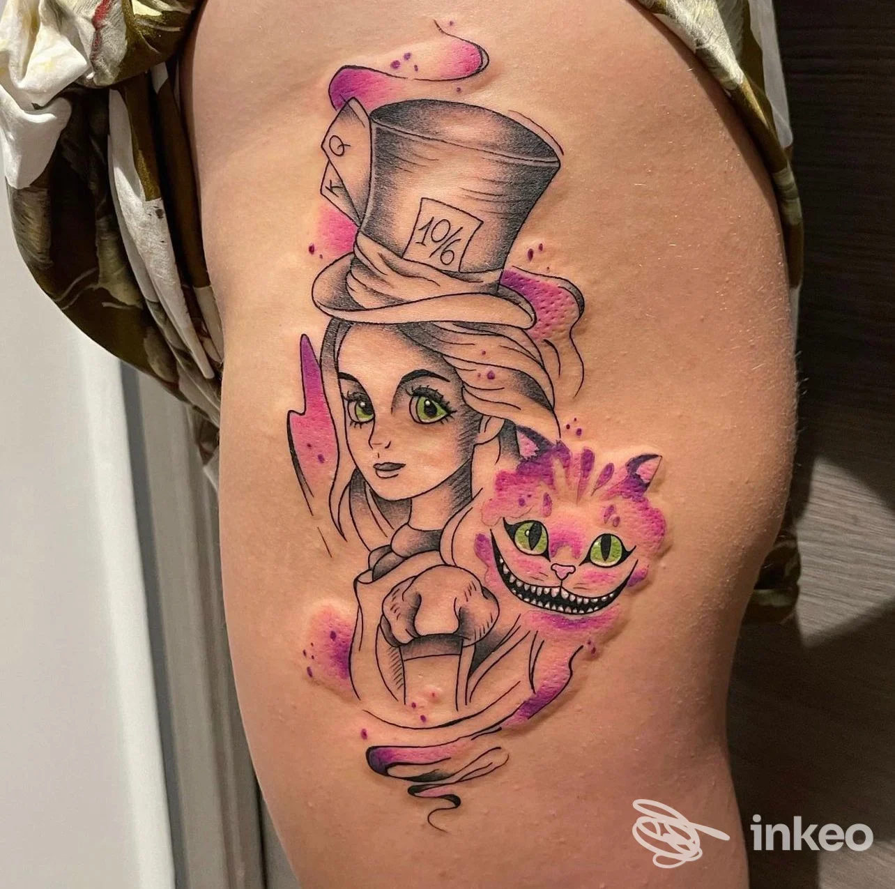 Tatuaggio su coscia con figura femminile e Gatto del Cheshire, realizzato da Tattoo &Piercing White Moon a Imperia.