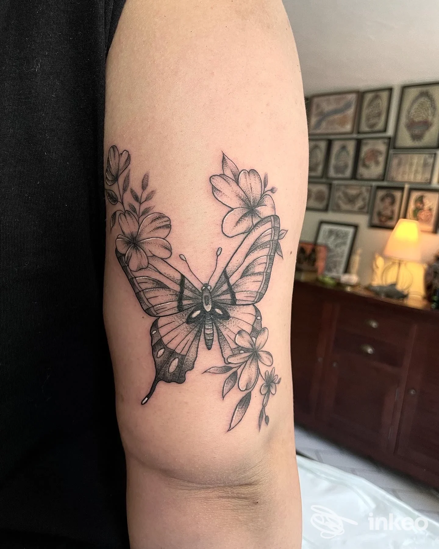 Tatuaggio a farfalla con fiori sull'interno del braccio, fotografia dello studio The Bishop Tattoo Studio, Laigueglia.