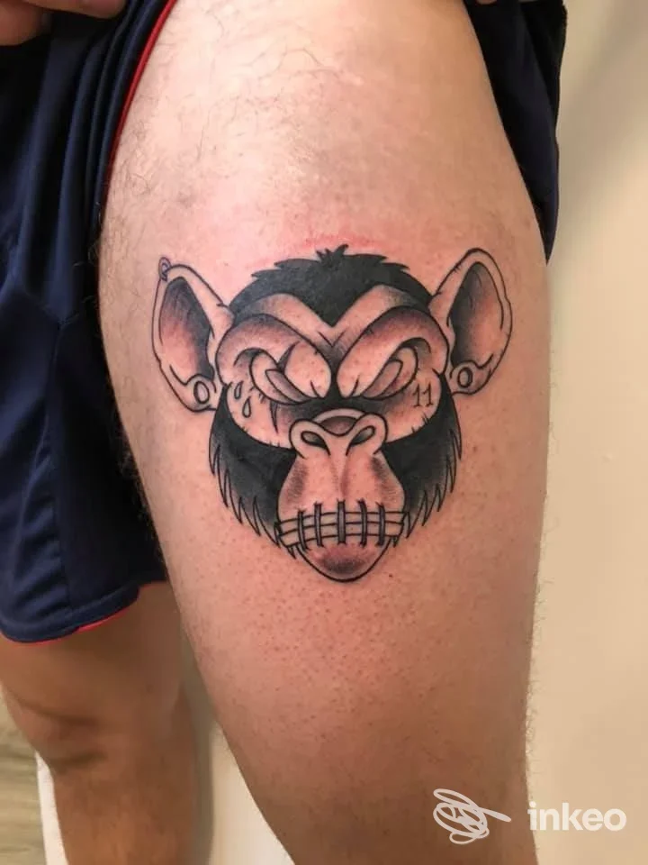 Tatuaggio testa di scimmia in nero e grigio sulla coscia, realizzato da Thunder Tattoo Shop a Diano Marina.