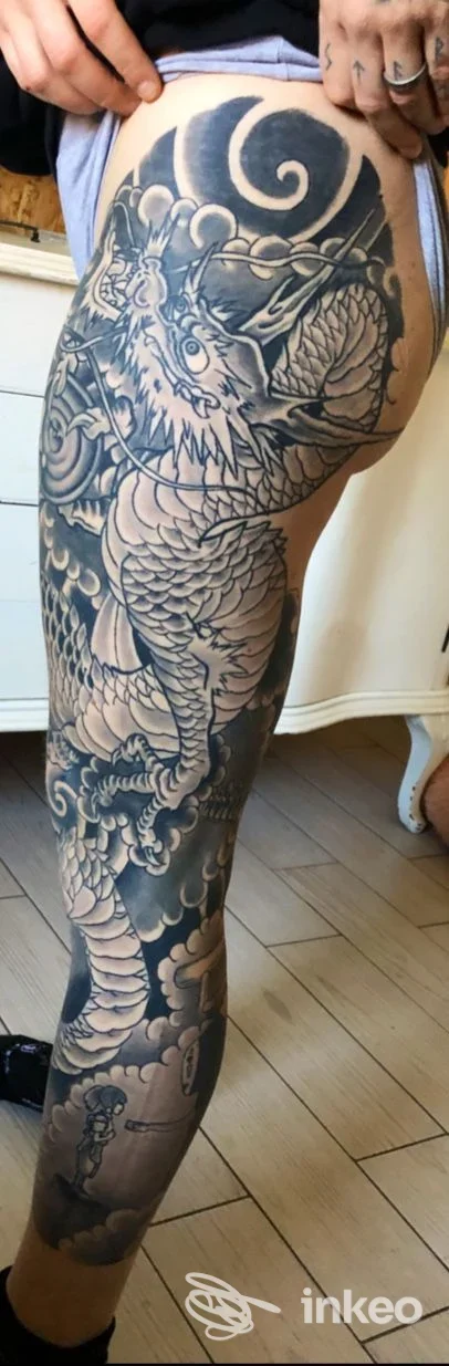 Ampio tatuaggio nero/grigio su gamba e coscia, foto verticale che mostra il lavoro eseguito da Vampirya Tattoo a Genova.