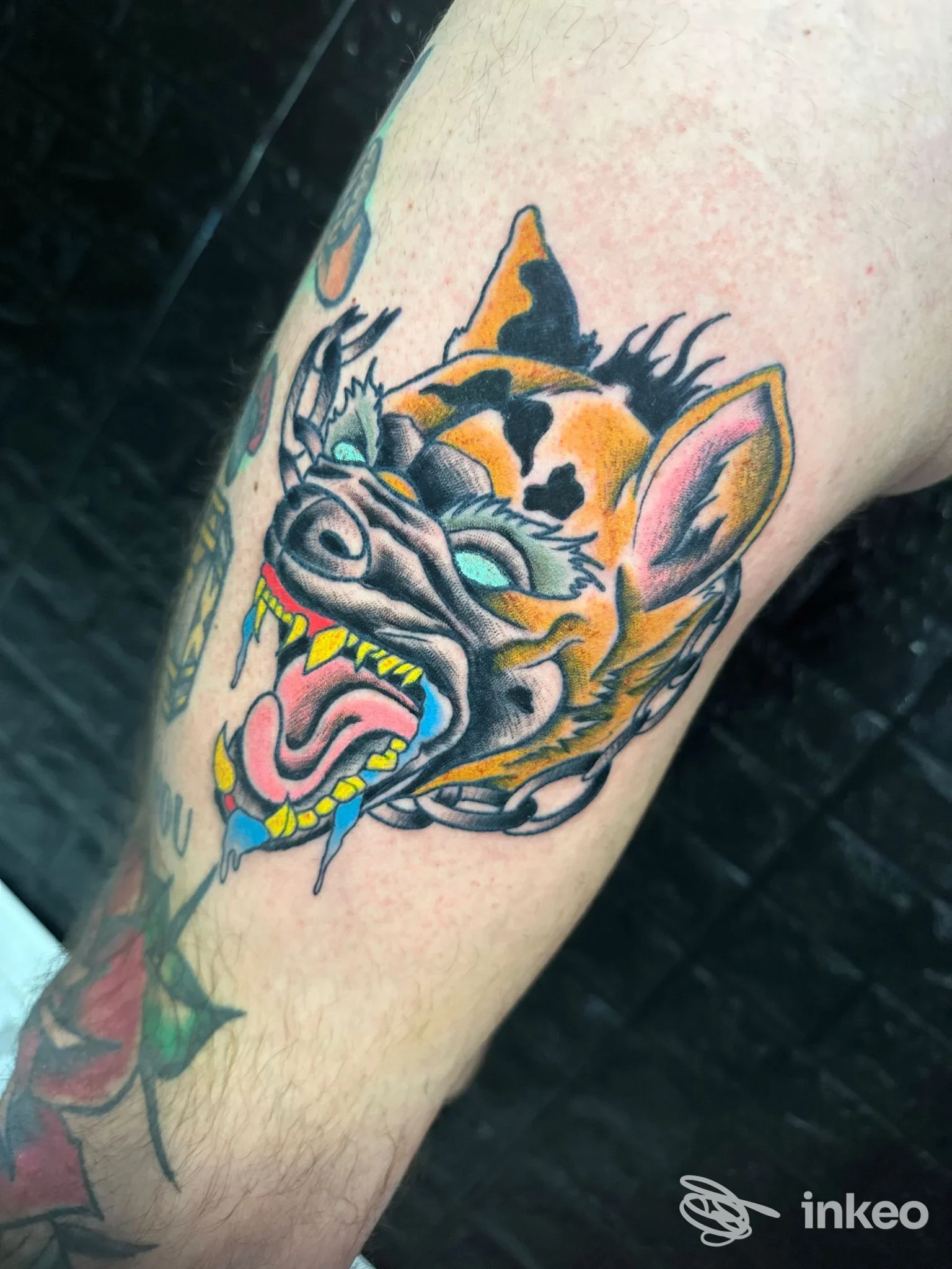 Primo piano di un tatuaggio a colori raffigurante una testa di animale sul braccio. Temple Tattoo, Genova.