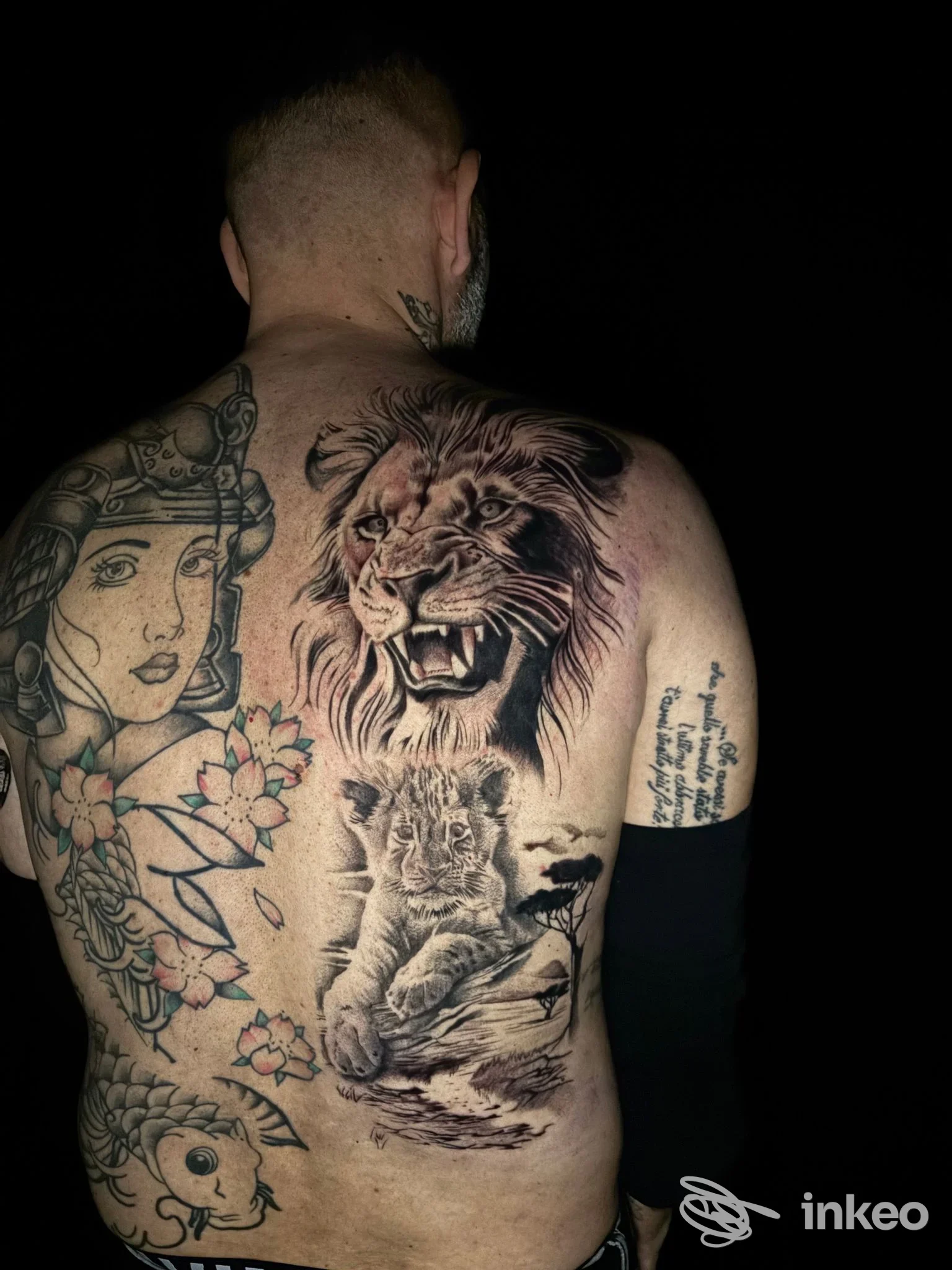 Grande tatuaggio realistico sul dorso con testa di leone e cucciolo, scatto dallo studio Temple Tattoo a Genova.