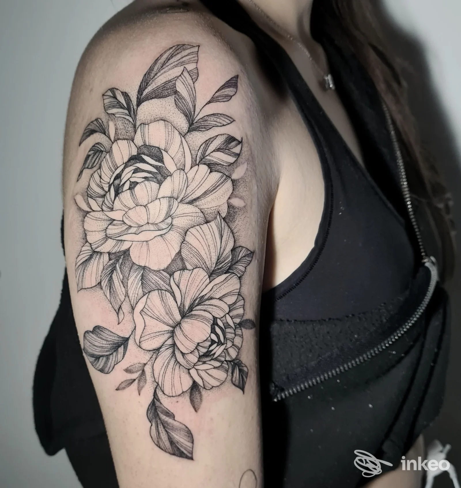 Tatuaggio floreale in nero sul braccio superiore, foto di mAmà Tattoo&Co. a La Spezia.