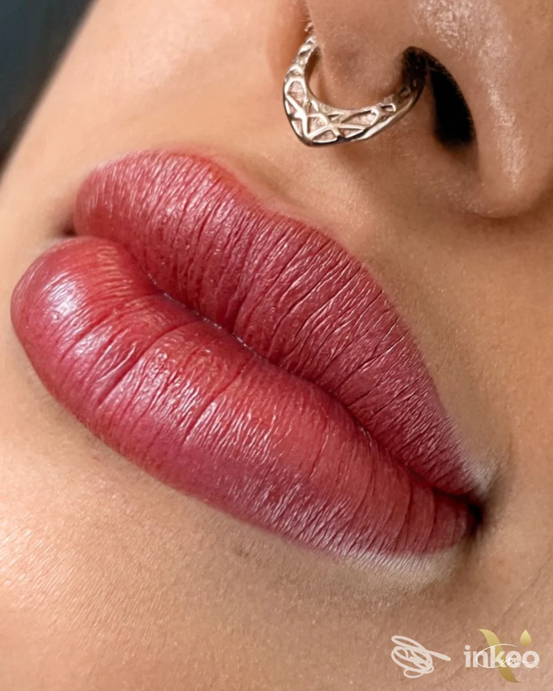 Primo piano dettagliato di labbra con trucco permanente rosso su pelle reale, opera di Veronica Carlini, Masone.